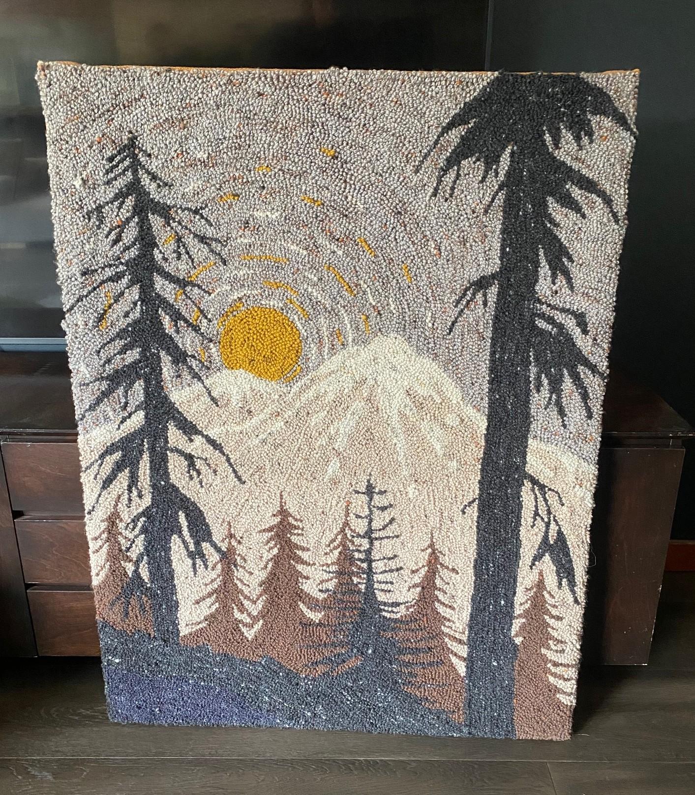 A beautiful and quite engaging large Mid-Century Modern tapestry/wall hanging.  The piece appears to be made of yarn or wool using a hand latch hook technique.  The piece features a wonderfully composed forest and mountain landscape scene with the
