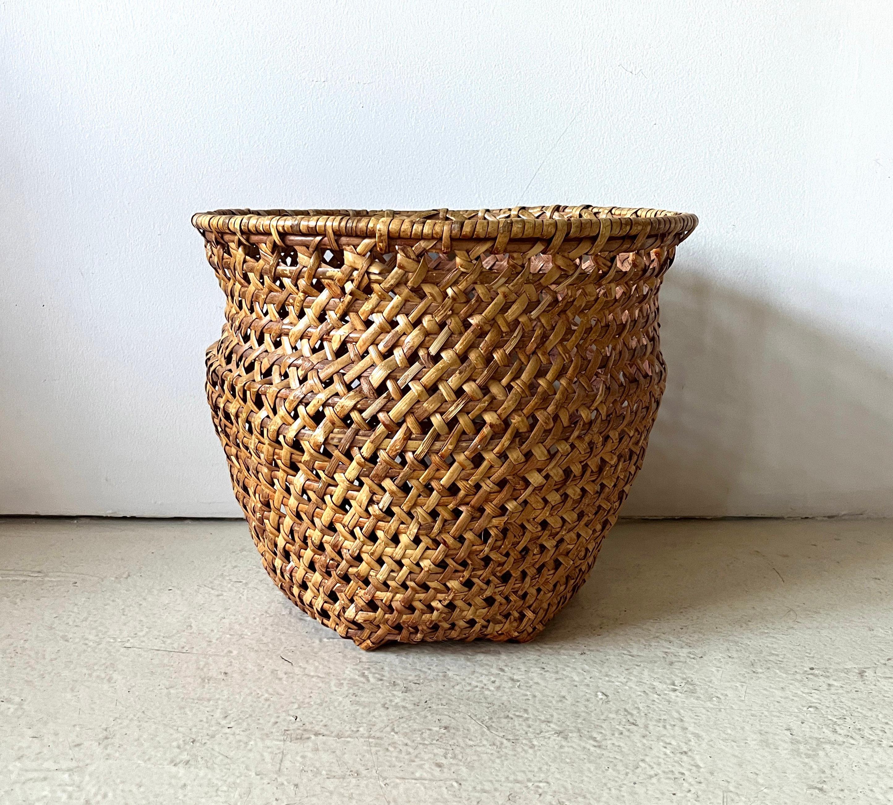 Sturdy and handsome woven urn-shaped basket of warm brown wicker or rattan with 1960s bohemian vibes. Tightly woven with hexagonal base. Great for storage, decor or to hold a potted plant. 

Very good to excellent vintage condition. No breaks or