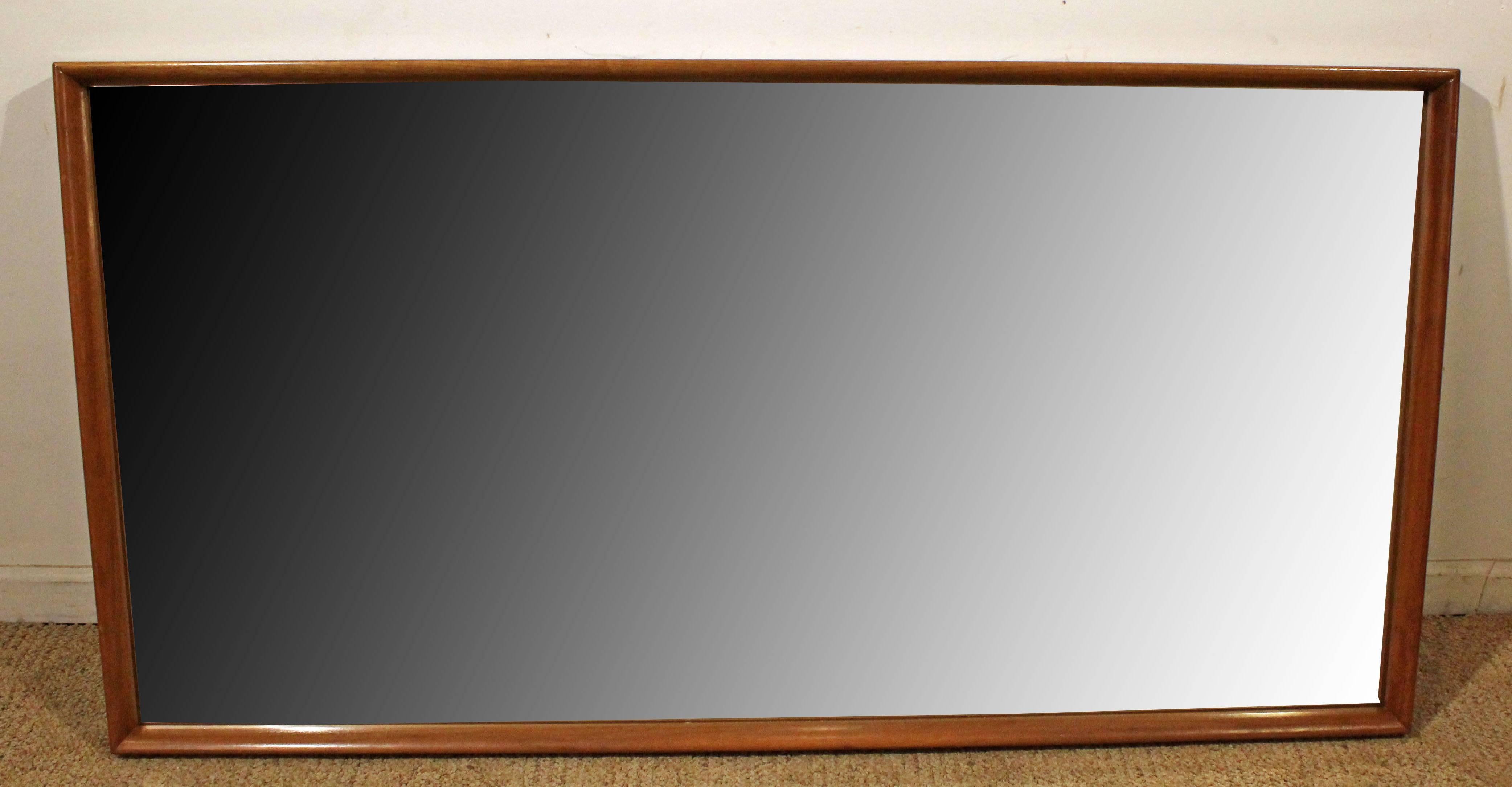 Offered is a very cool midcentury wall mirror. Features a walnut frame. It is in excellent condition, showing some age wear. It is not signed.

Approximate dimensions: 
61.5