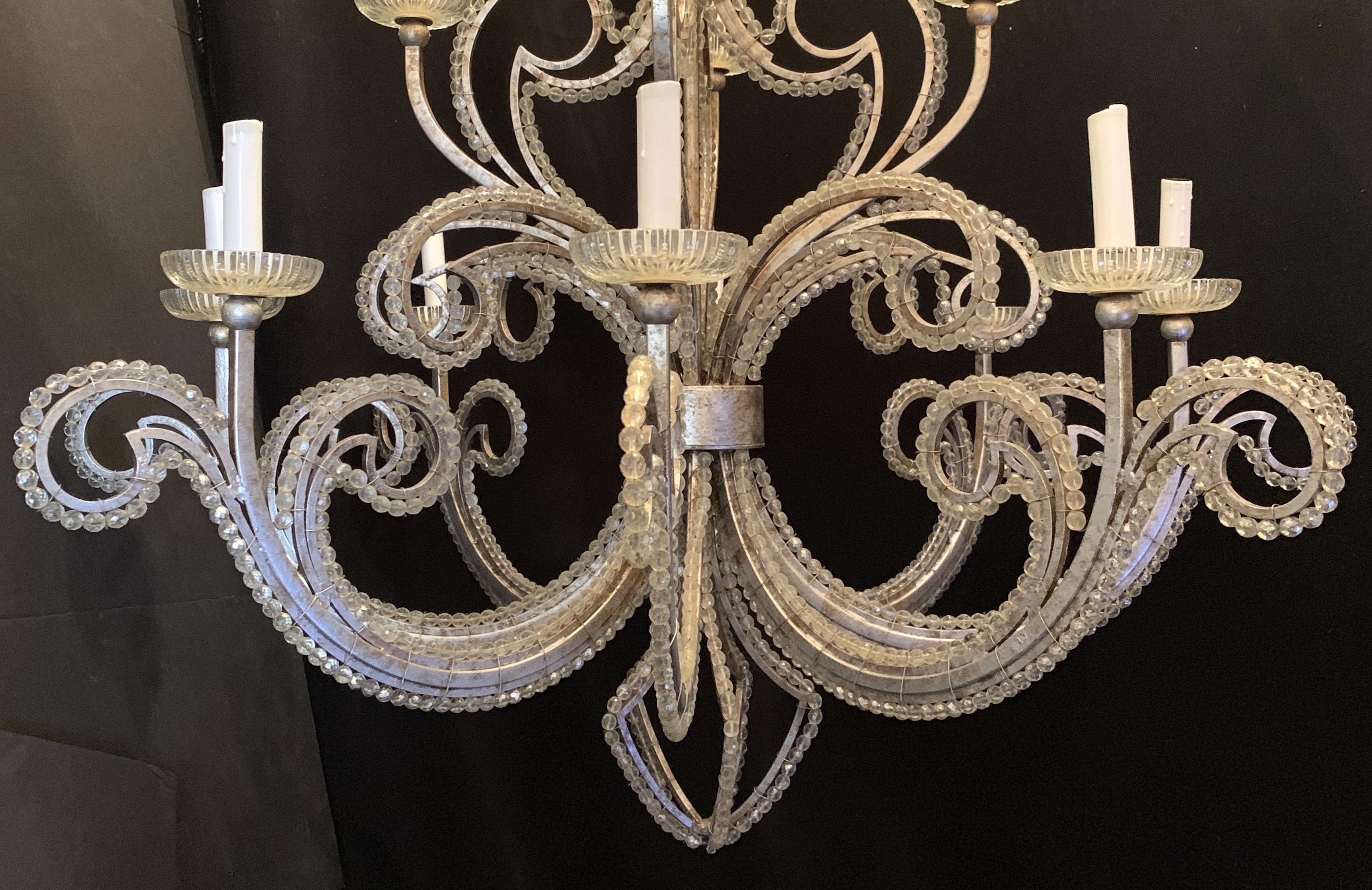 A wonderful large Mid-Century Modern silver leaf two-tier beaded 12-light chandelier with cut crystal cups in the manner of Baguès.