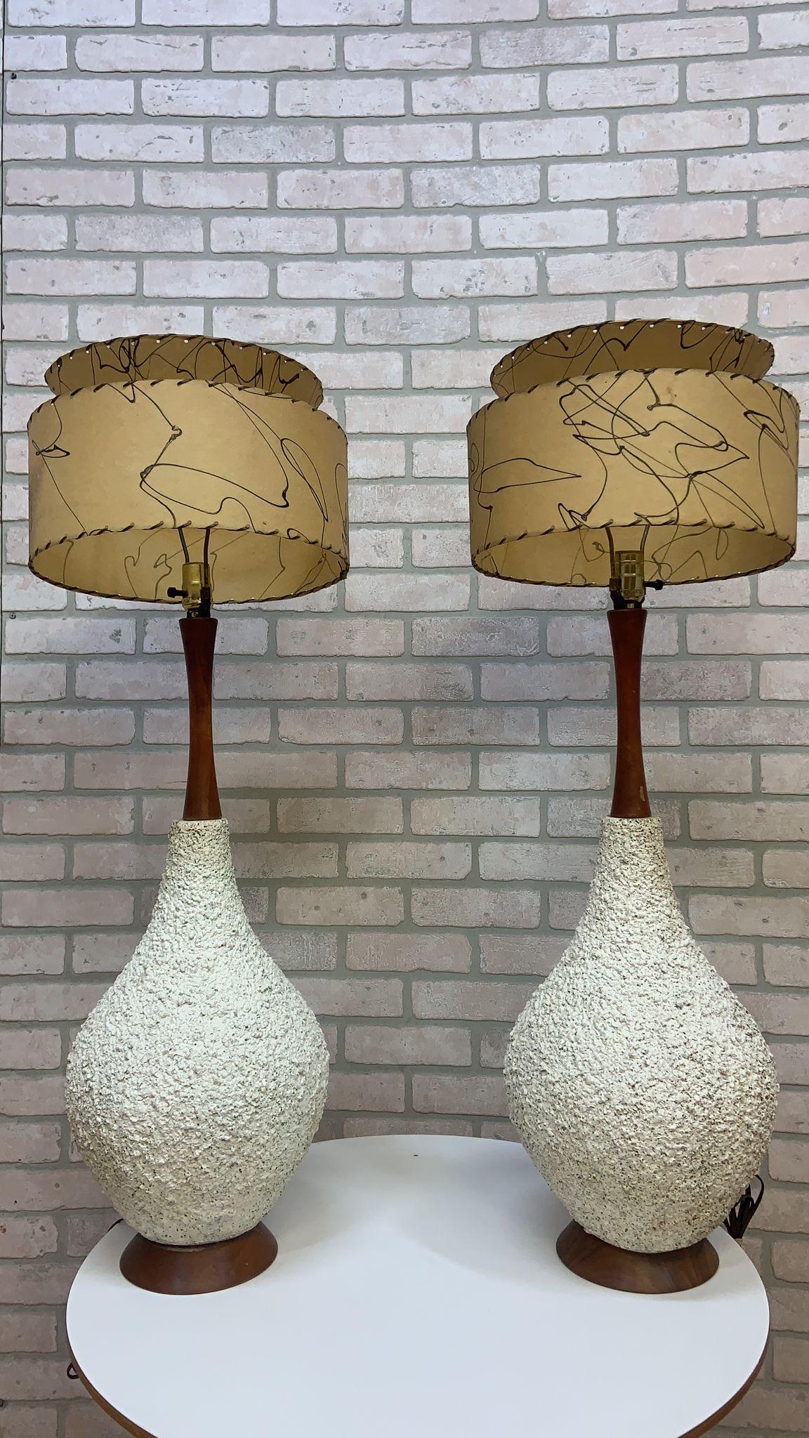 Mid Century-Modern Large Teak Popcorn Base Table Lamps - Pair

A very cool pair of large table lamps from the 1950s. They are constructed out of teak and plaster to create the popcorn texture on the lamps.

Lamps have been tested and they are in