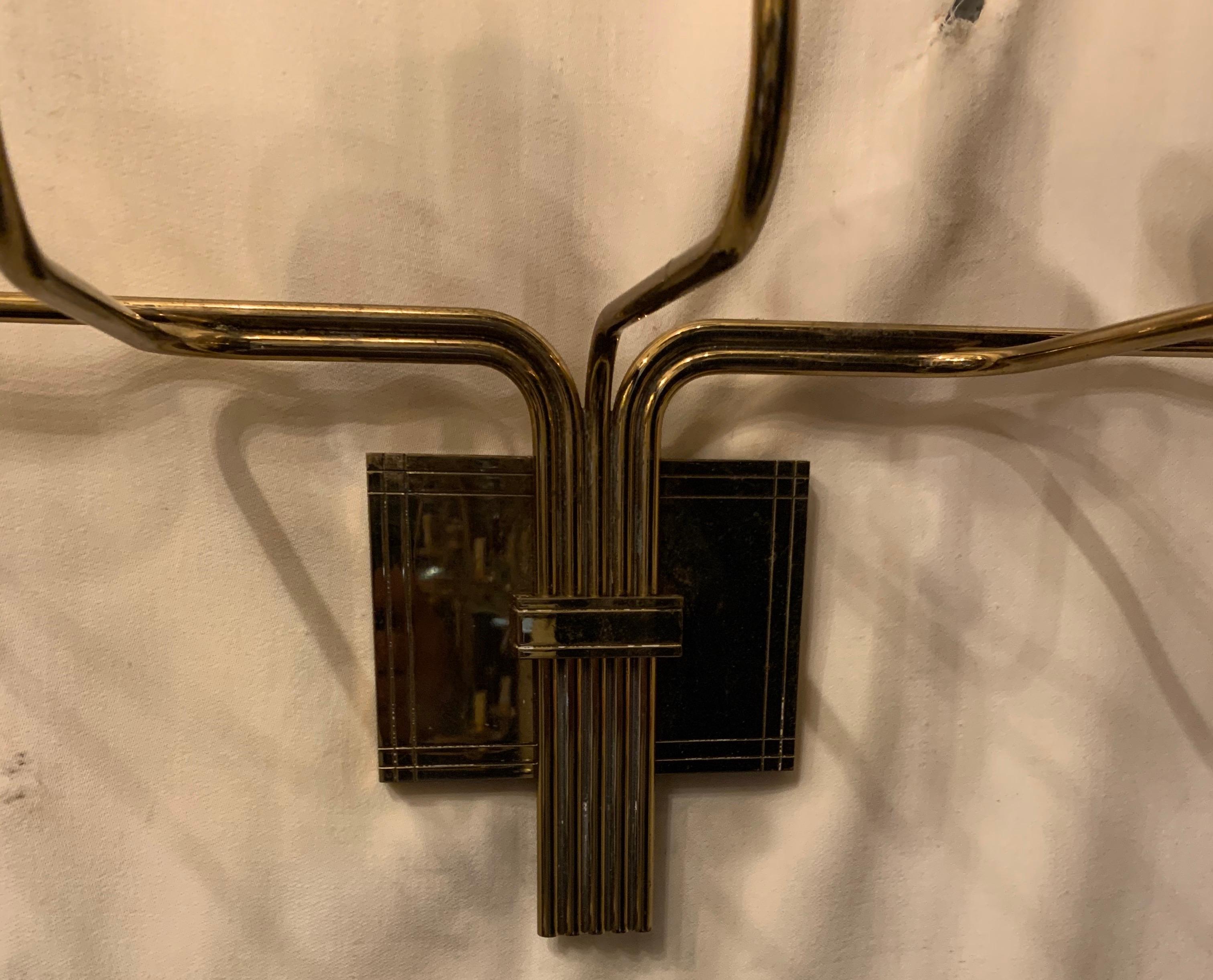An elegant Mid-Century Modern large five-arm candle sconce designed by Tommi Parzinger, manufactured by Dorlyn Silversmiths.
Each arm extends from a group mounted on a rectangular back plate with an incised linear design.