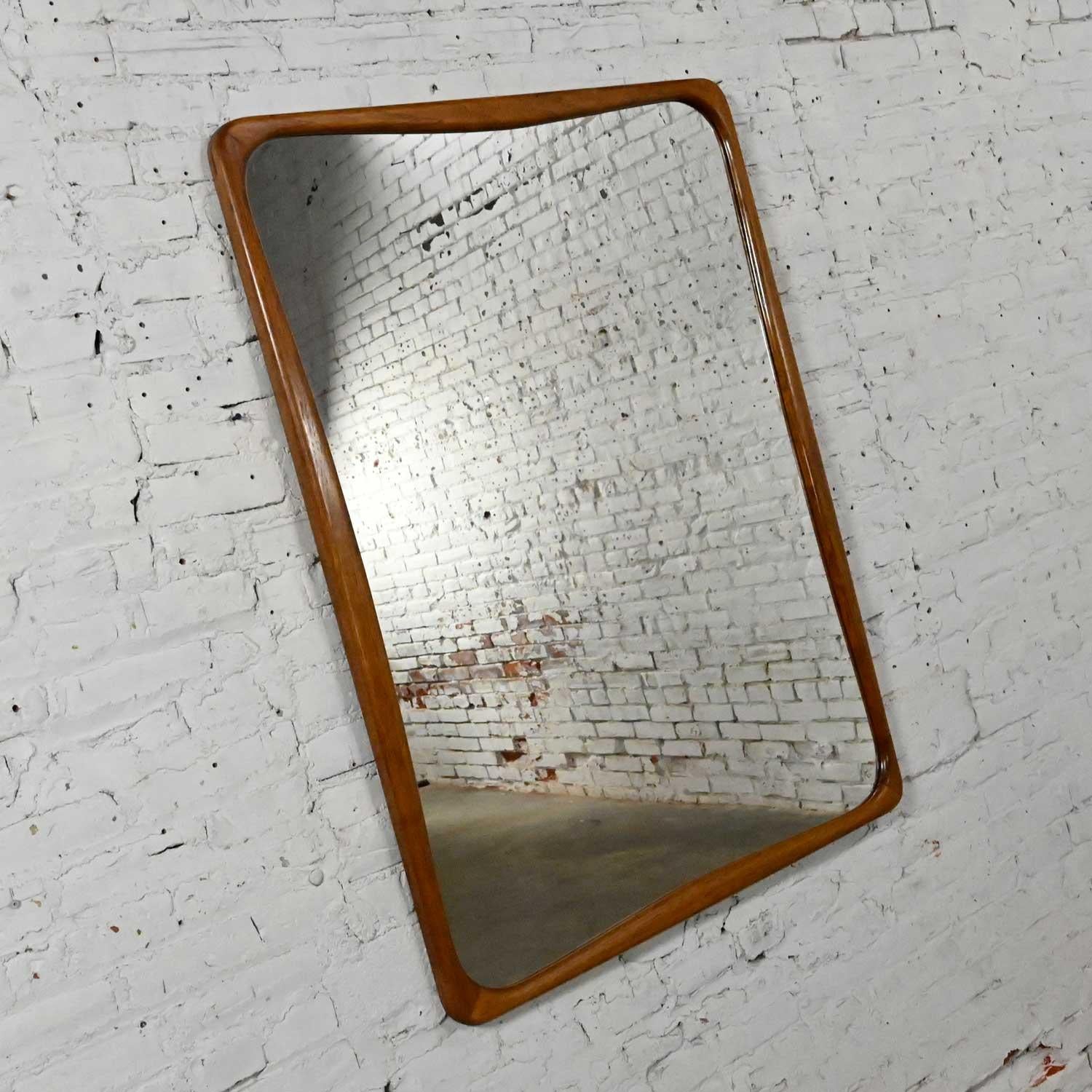 Handsome large walnut framed mirror attributed to Lane Furniture’s Perception line. This piece does not have a mark or tag. Beautiful condition, keeping in mind that this is vintage and not new so will have signs of use and wear. It has a new mirror