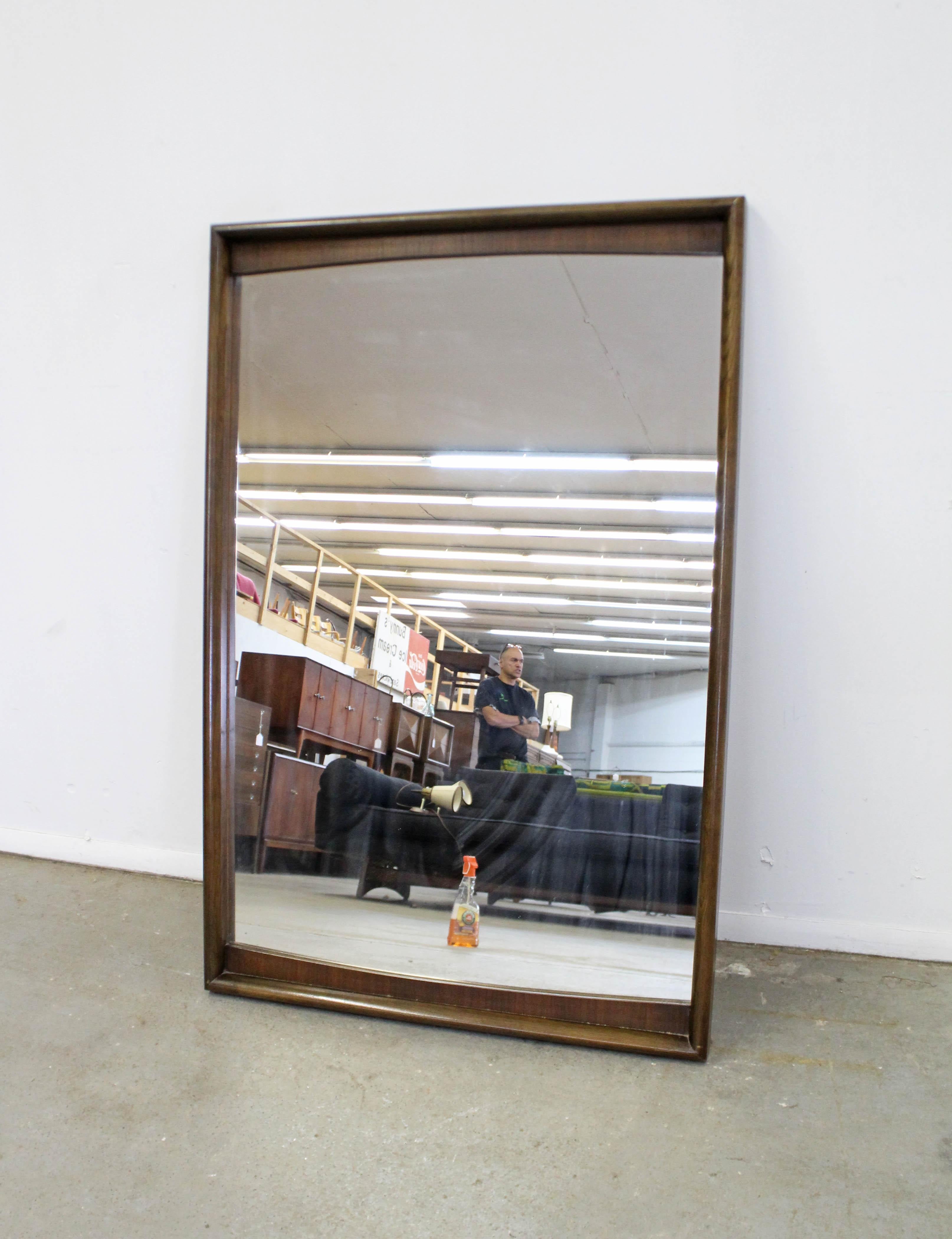 Offered is a vintage Mid-Century Modern wall mirror made by United Furniture. This piece is large and heavy with a walnut frame. It is in good condition shows minor wear including small nicks and scratches on the wood. Does not include a hanger. It