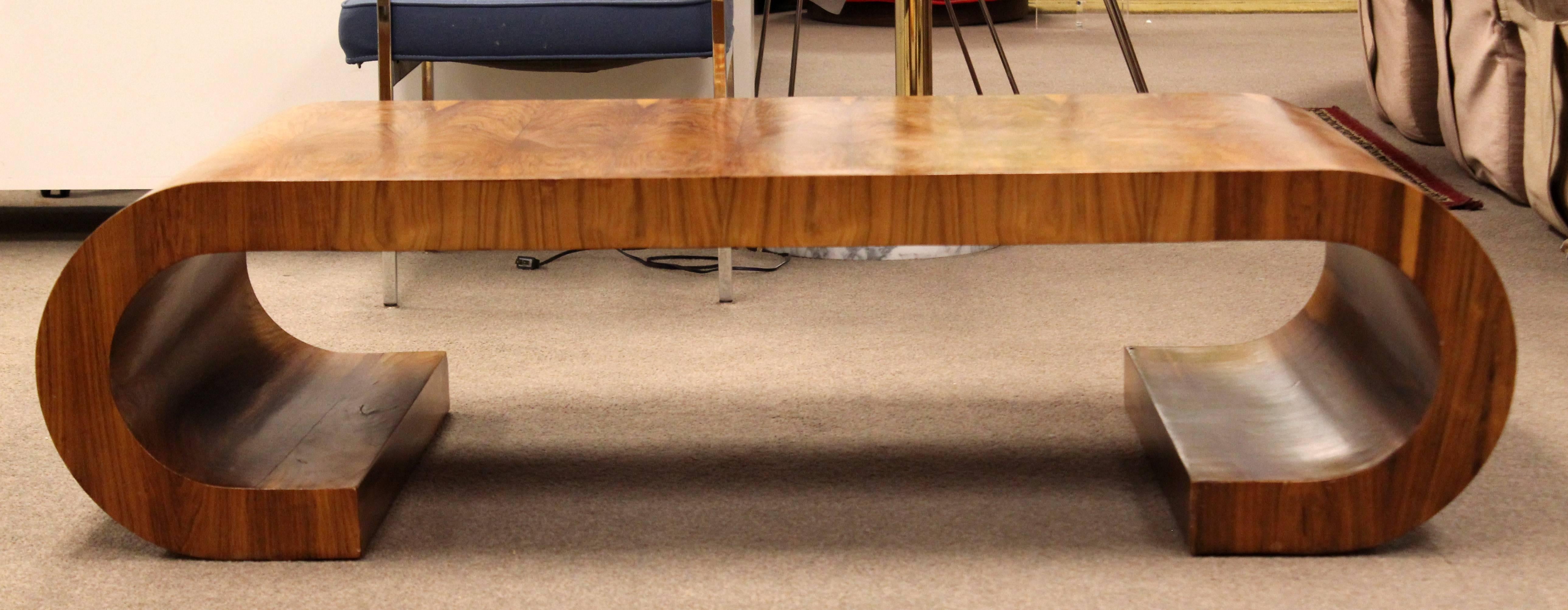 For your consideration is a stunning, curved wood coffee table, in the style of Milo Baughman, circa the 1960s. In very good condition. The dimensions are 55.5