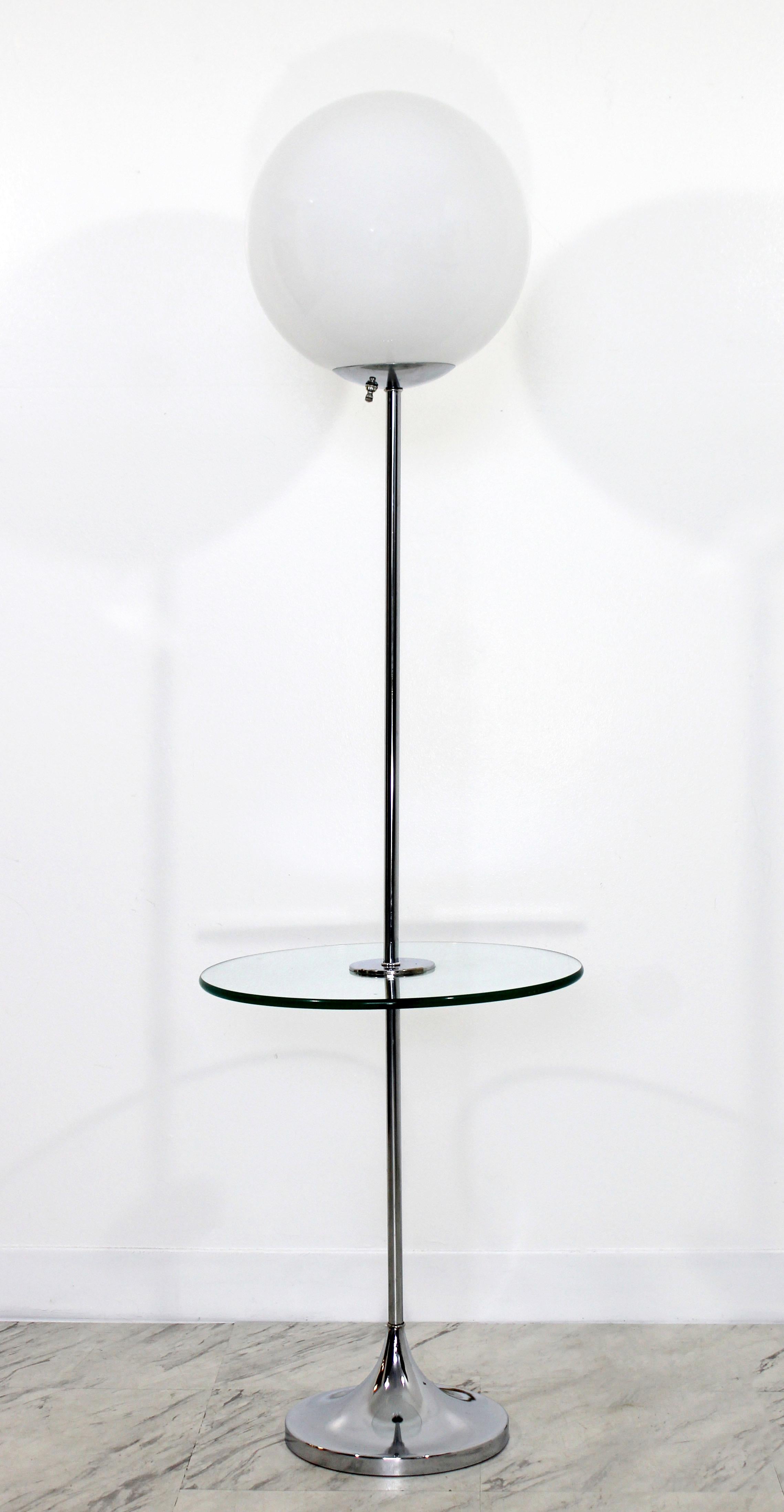 For your consideration is an utterly fabulous, floor lamp table, made of chrome, with a round glass table and glass globe top, in the style of Laurel Lamps, circa the 1970s. In very good condition, with natural patina to chrome. The dimensions 16