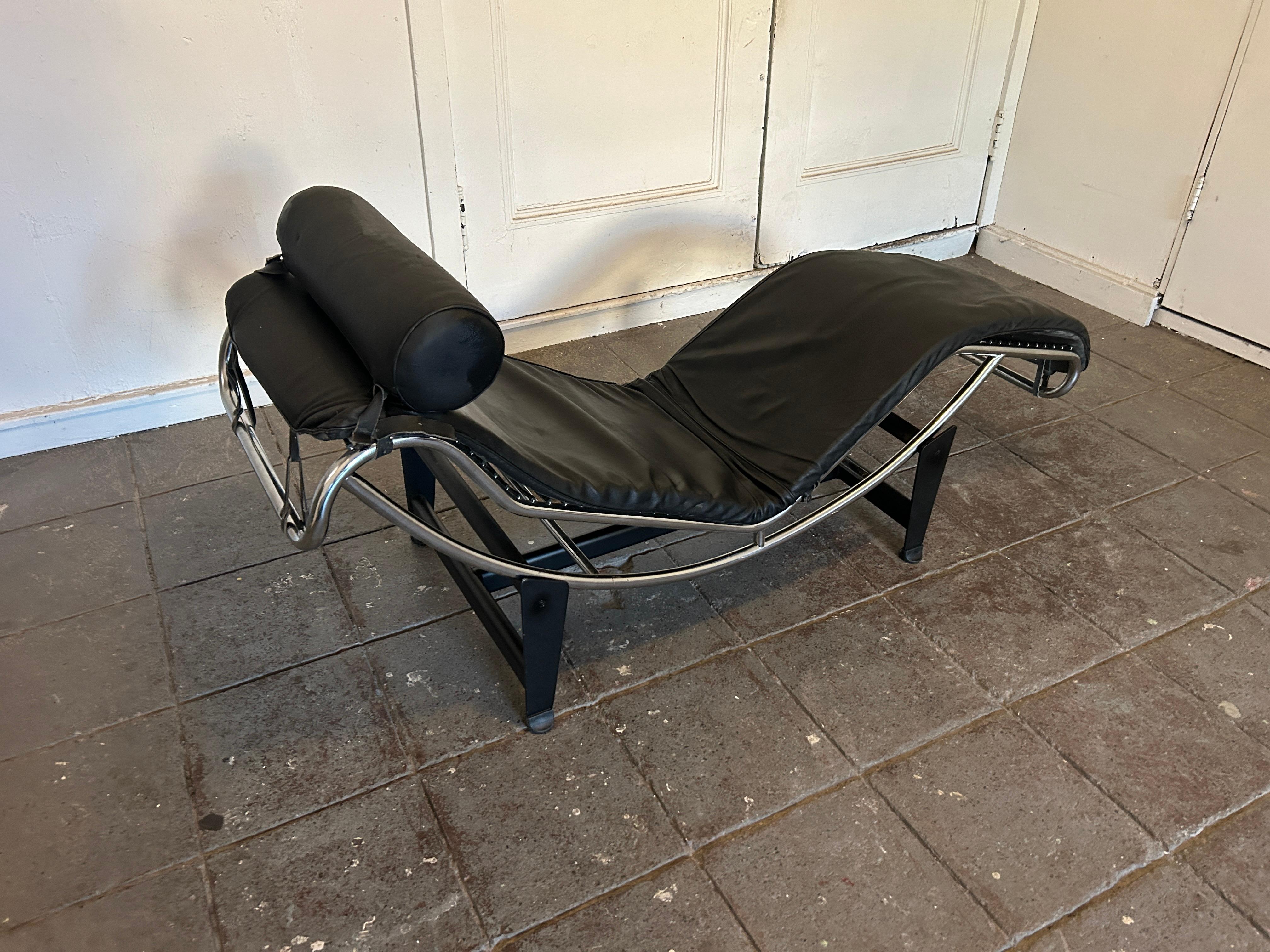 Una chaise lounge LC4 di Le Corbusier in stile moderno. Progettato da Charlotte Perriand, Le Corbusier, Perriand e Pierre Jeanneret. La sedia è in pelle nera spessa con una struttura in acciaio cromato e una base nera. La pelle è in condizioni