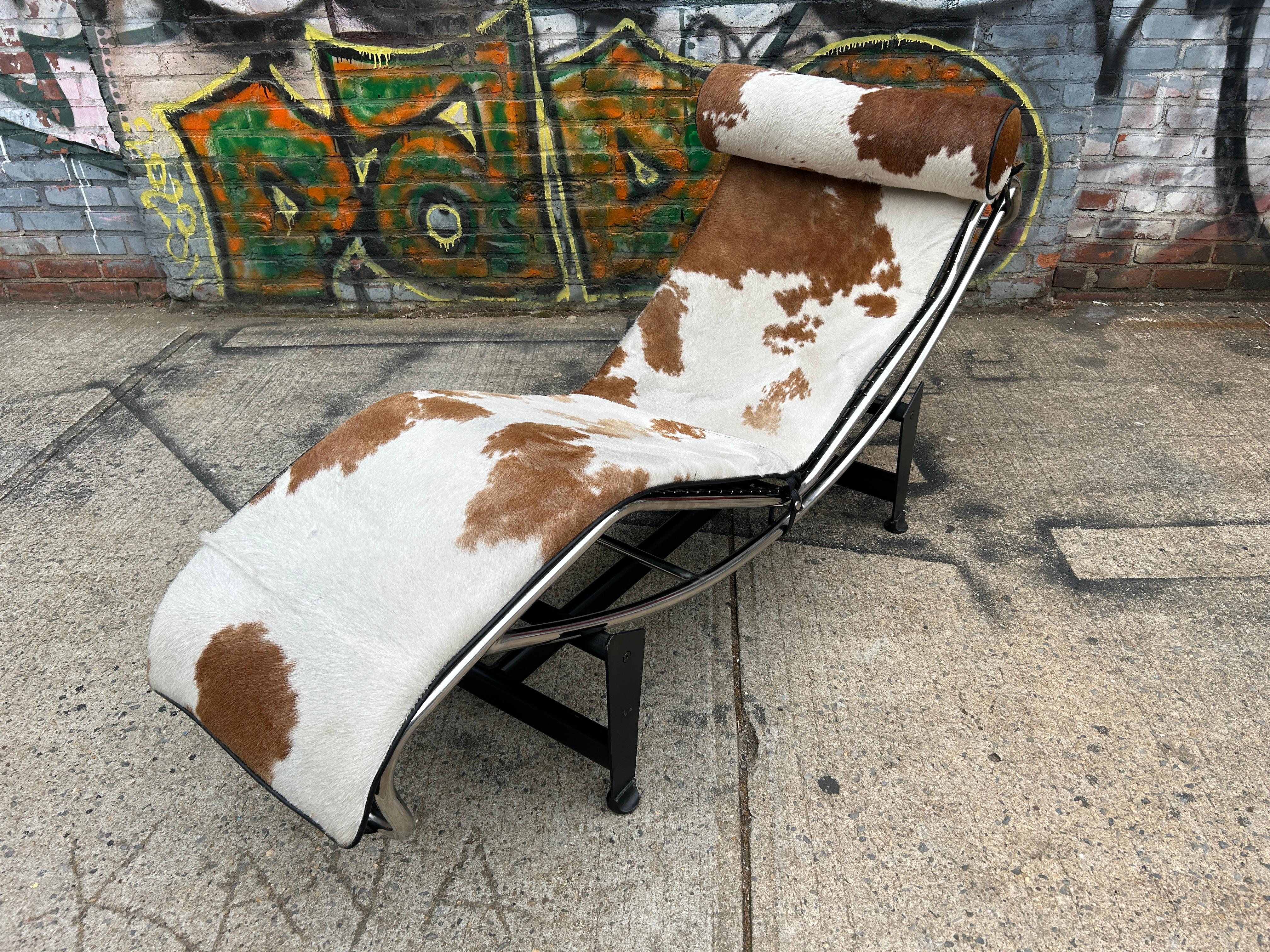 Un estilo moderno de chaise lounge LC4 de Le Corbusier. Diseñado por Charlotte Perriand, Le Corbusier y Pierre Jeanneret-Gris. La silla es de piel de vaca marrón y blanca, con armazón de acero cromado y base negra. El cuero está en estado original,