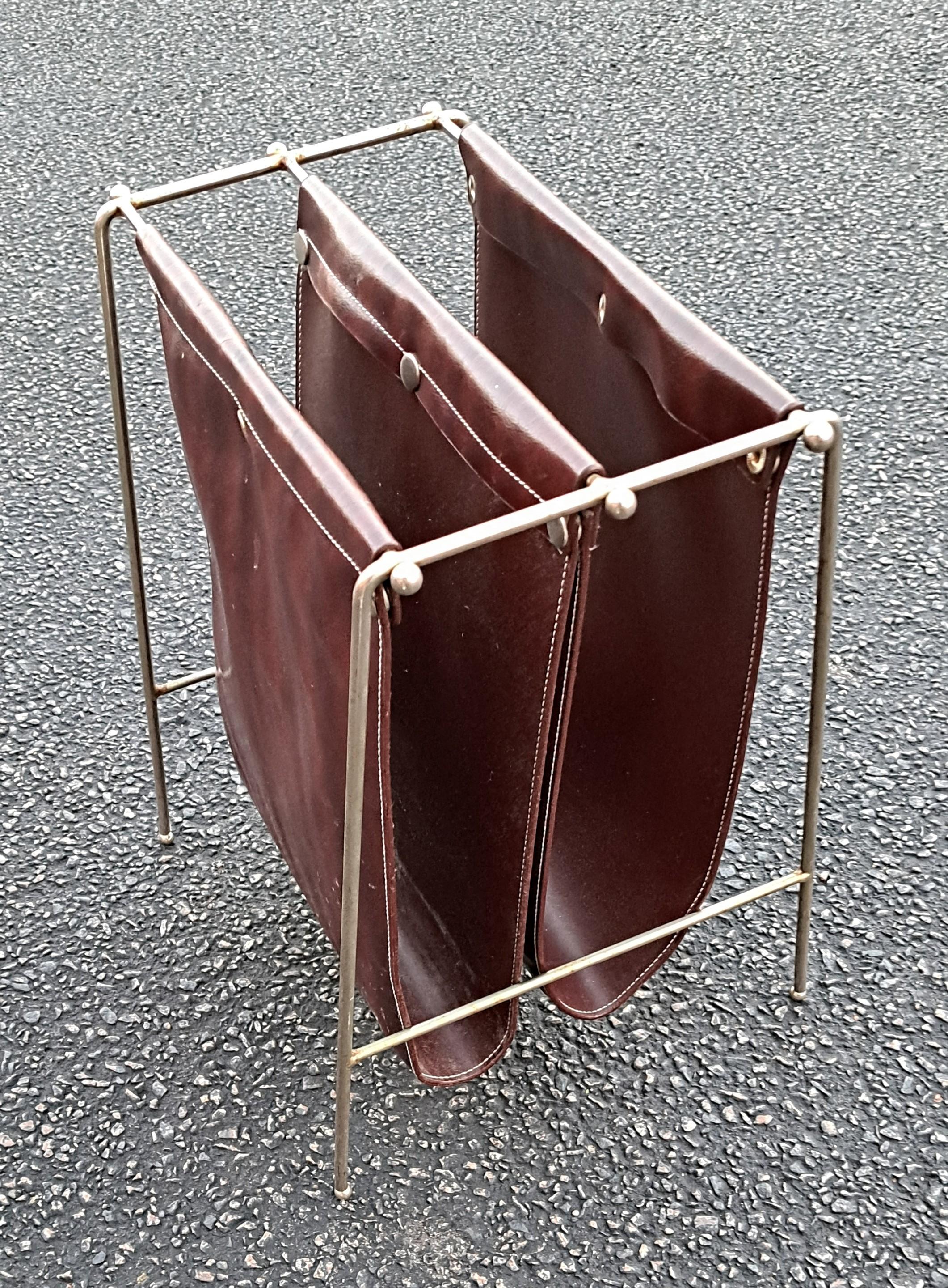 Classic mid-century modern Jacques Adnet attributed magazine rack. Stylishly made with faux leather and bent iron rods. This hard to find magazine rack exudes mid-century modern style. Can be used for magazines or LPs.