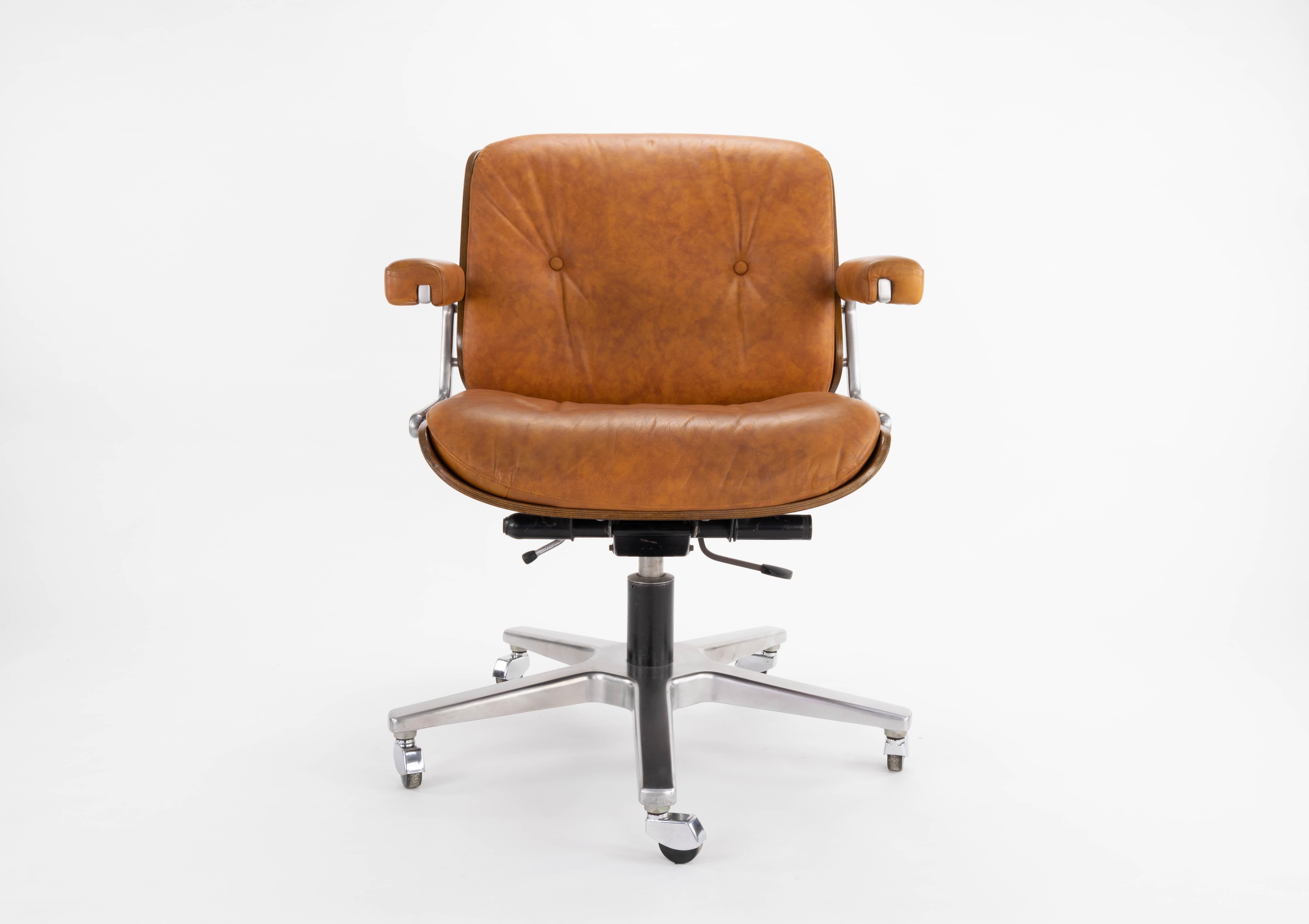 Armchair designed by Martin Stoll for the Swiss firm Giroflex in the 1960s. Laminated wood structure, original camel leather upholstery in very good condition. The chair is swivel and adjustable in height and inclination. All their fish are original