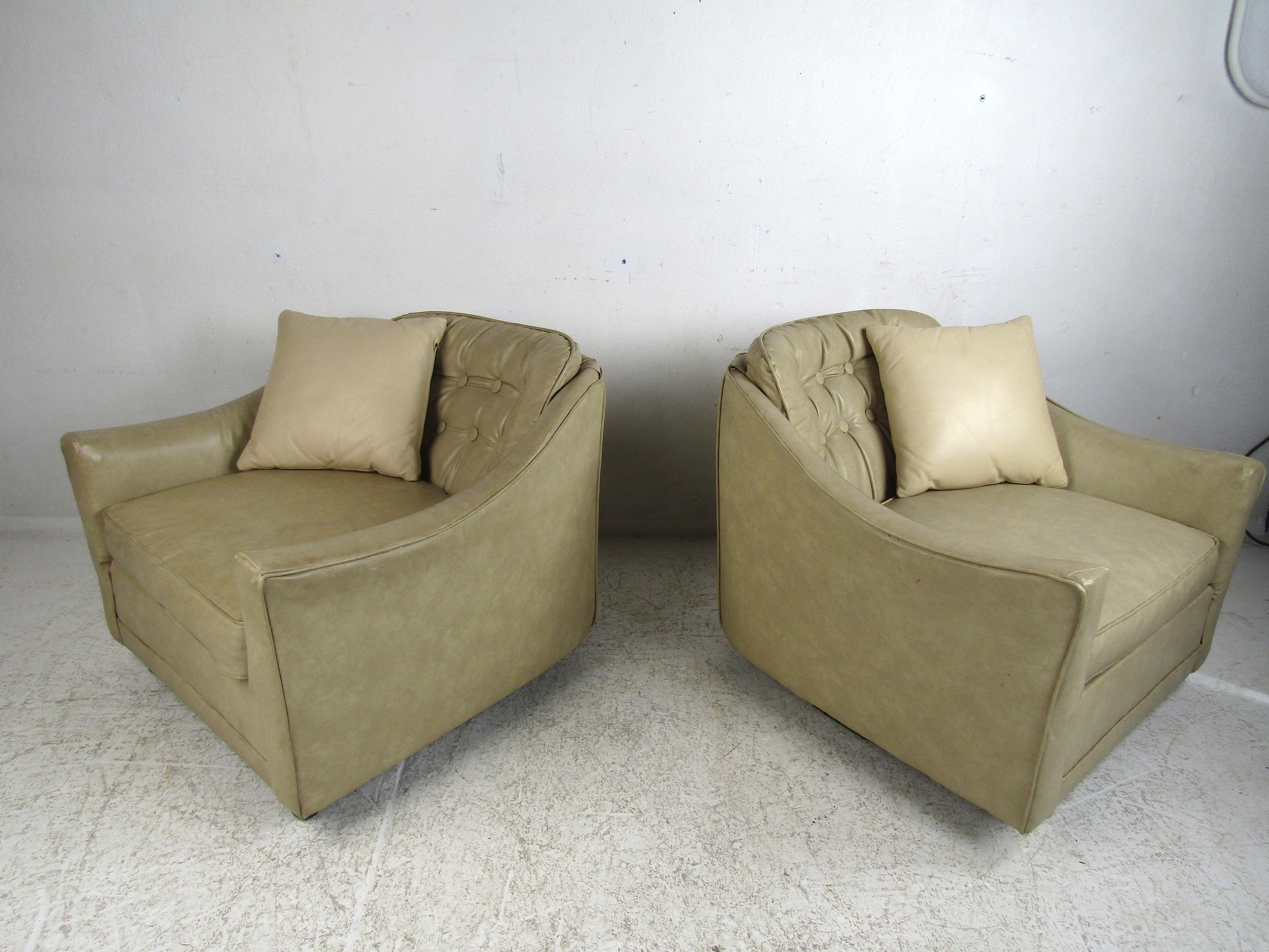 Pair of Mid-Century Modern club chairs by Selig covered in leather upholstery. Tufted backrests with sloped armrests give these chairs a great look. This pair would make a great addition to any modern interior. Please confirm item location with