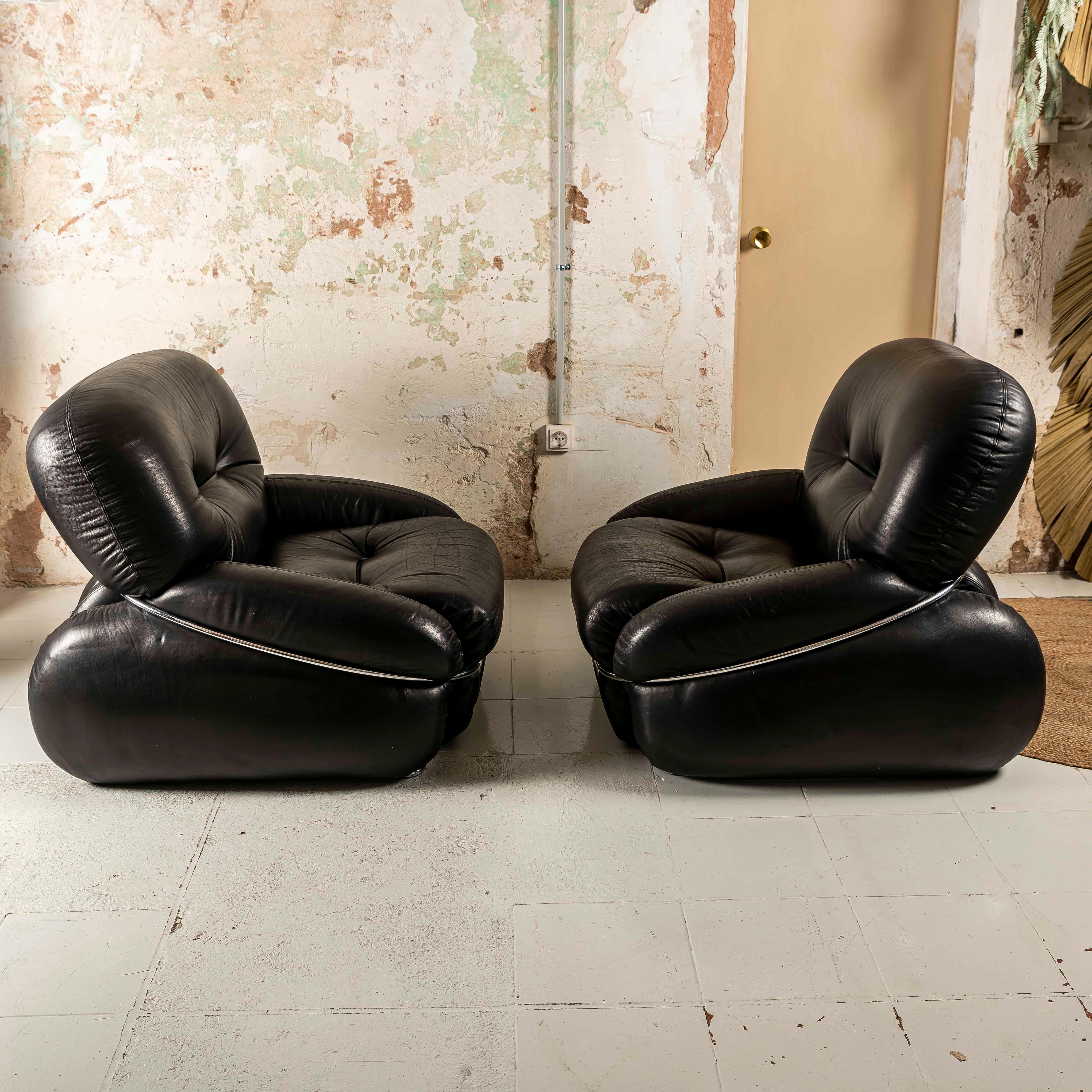 e sedie lounge Adriano Piazzesi OKAY, realizzate in lussuosa pelle nera e con eleganti telai tubolari cromati, sono una perfetta combinazione di raffinatezza e design moderno. Il rivestimento in pelle nera offre un fascino audace ma senza tempo,