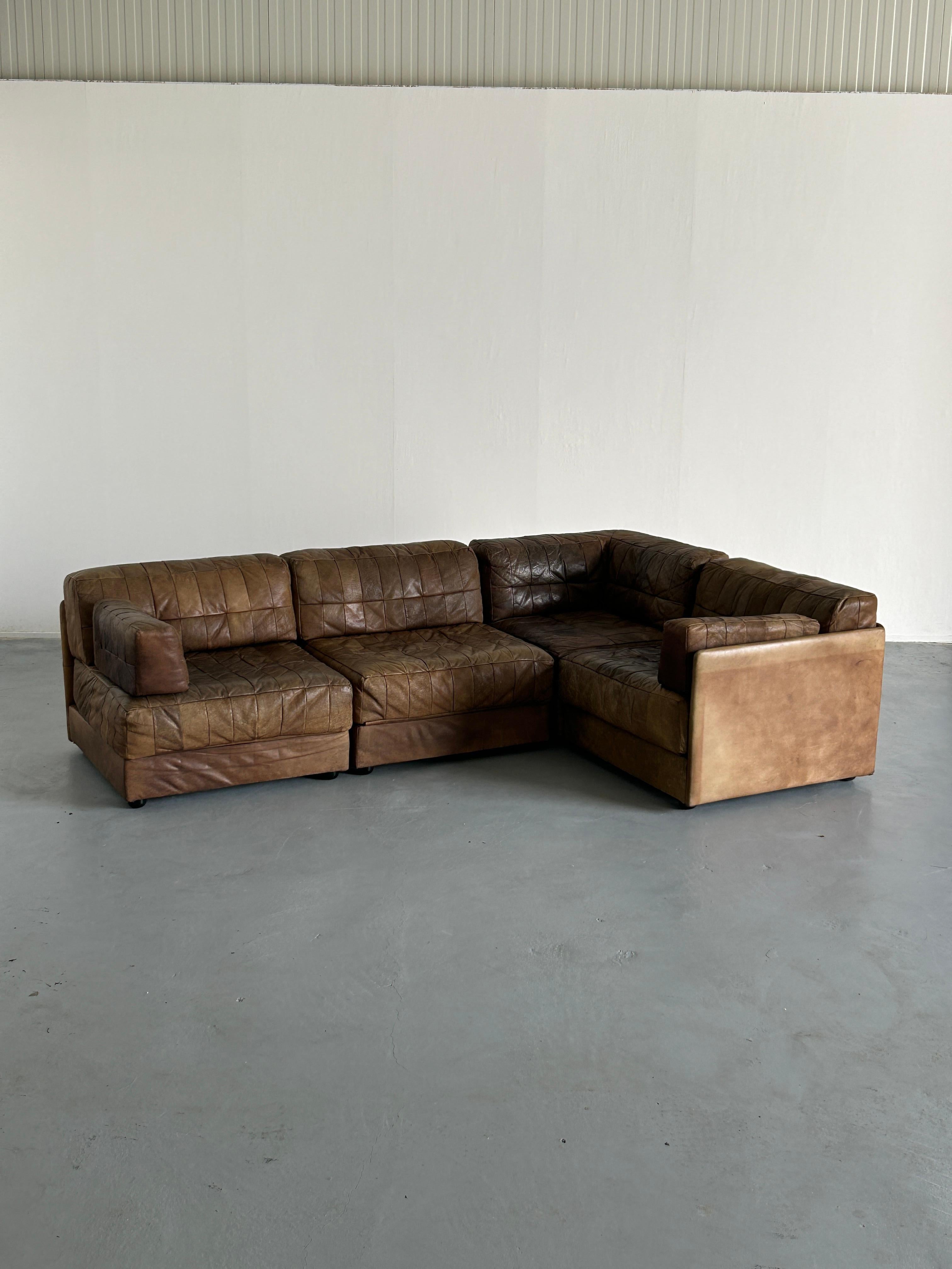A stunning four-part Mid-Century-Modern patchwork leather modular sofa, produced in the early 1970s in West Germany, and following the style of the 1970s De Sede modular sofas.

A 1970s statement of comfort, three of the four modules fold out into