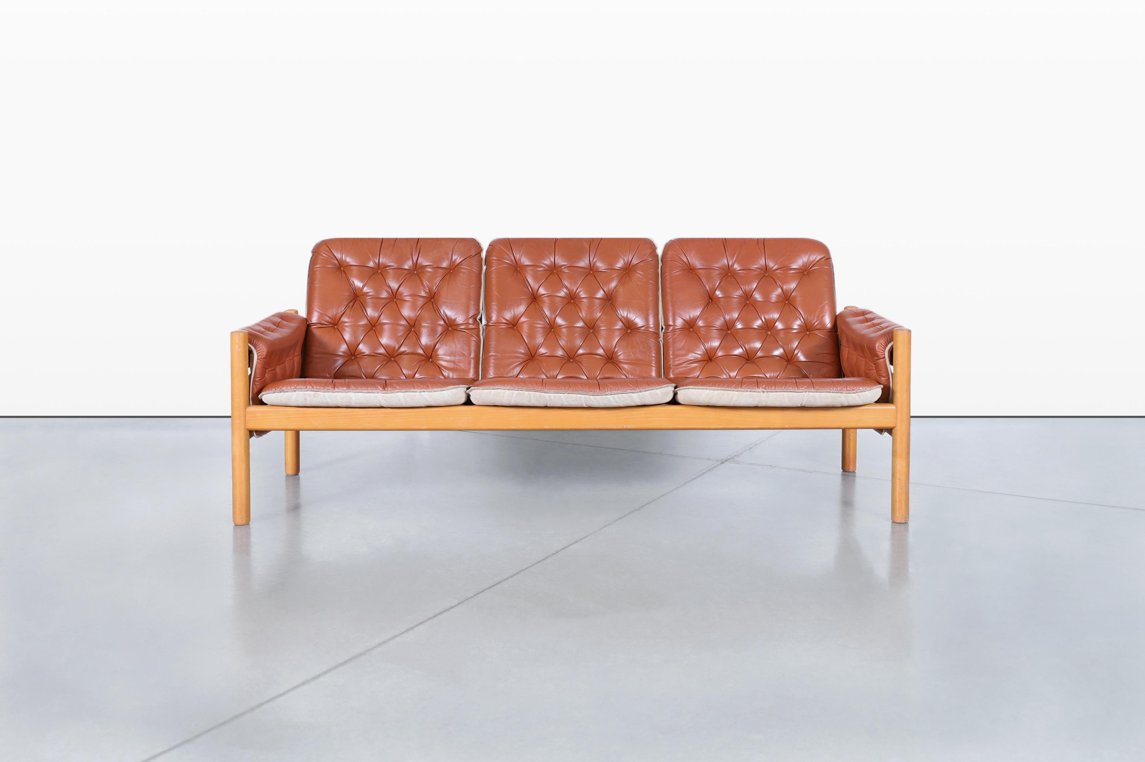 An exquisite vintage leather safari sofa designed by Kjell Nordin in the 1980s, part of the iconic IREVIK collection from Sweden, and masterfully manufactured by Ikea. This stunning piece features luxurious brown leather cushions, showcasing a