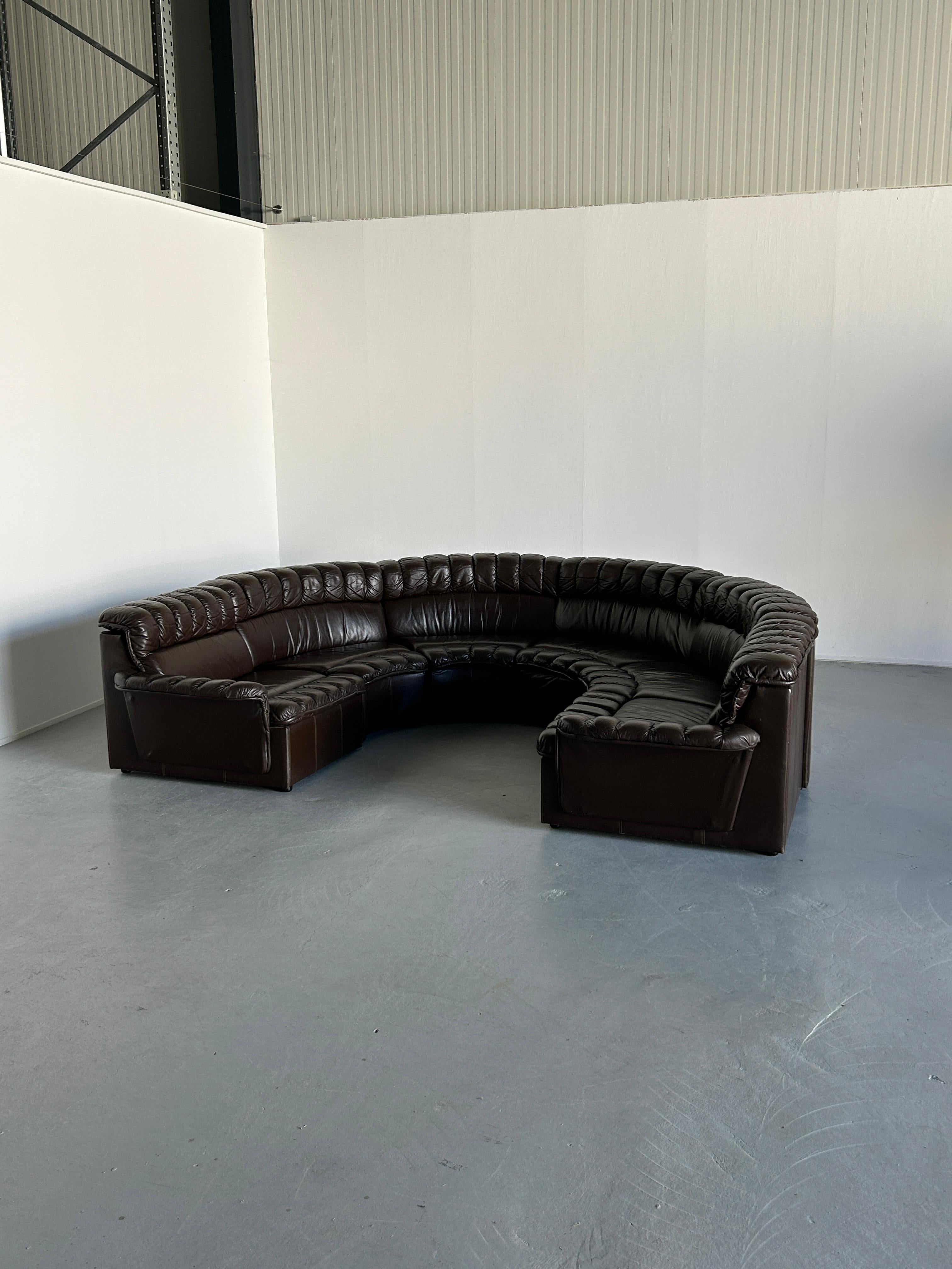 A stunning seven-part Mid-Century Modern leather U-shape sectional sofa, produced in the late 1970s in West Germany, and following the style of the De Sede DS-600 Non Stop stofa, designed by Ueli Berger, Eleanora Peduzzi-Riva, and Hans Ulrich.

A