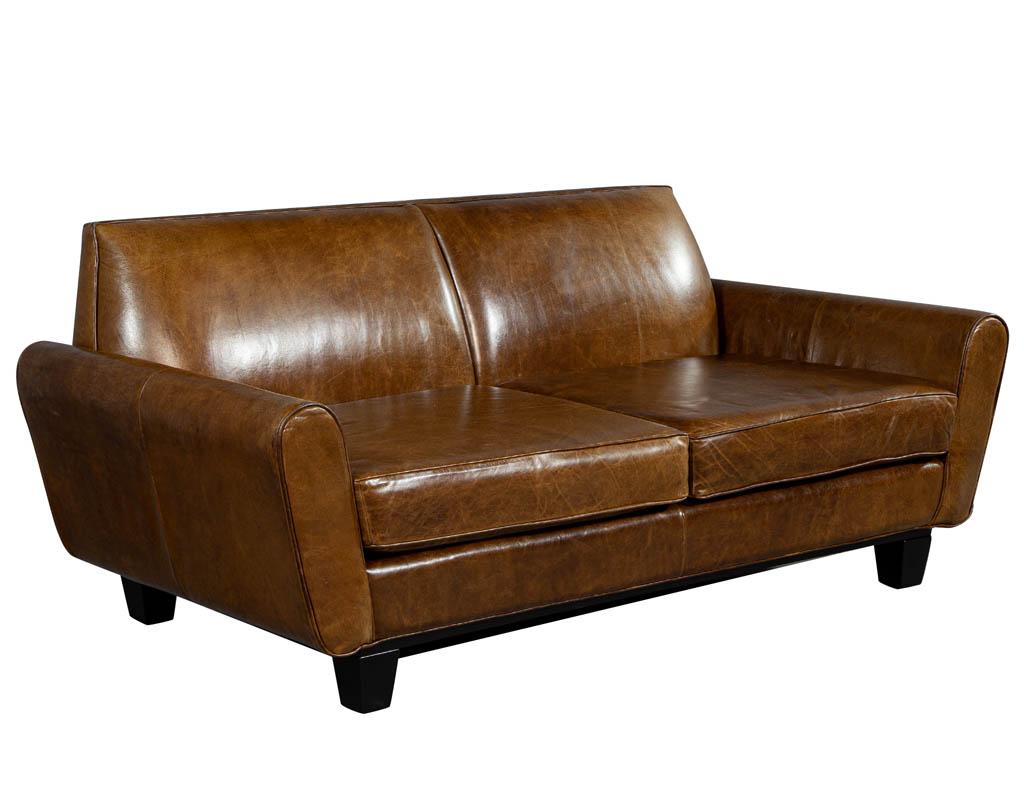 Mid-Century Modern leather sofa loveseat. Featured in a camel color leather, aged and distressed to a beautiful vintage patina. Perfect addition to a living room or office space.

Price includes complimentary curb side delivery to the continental