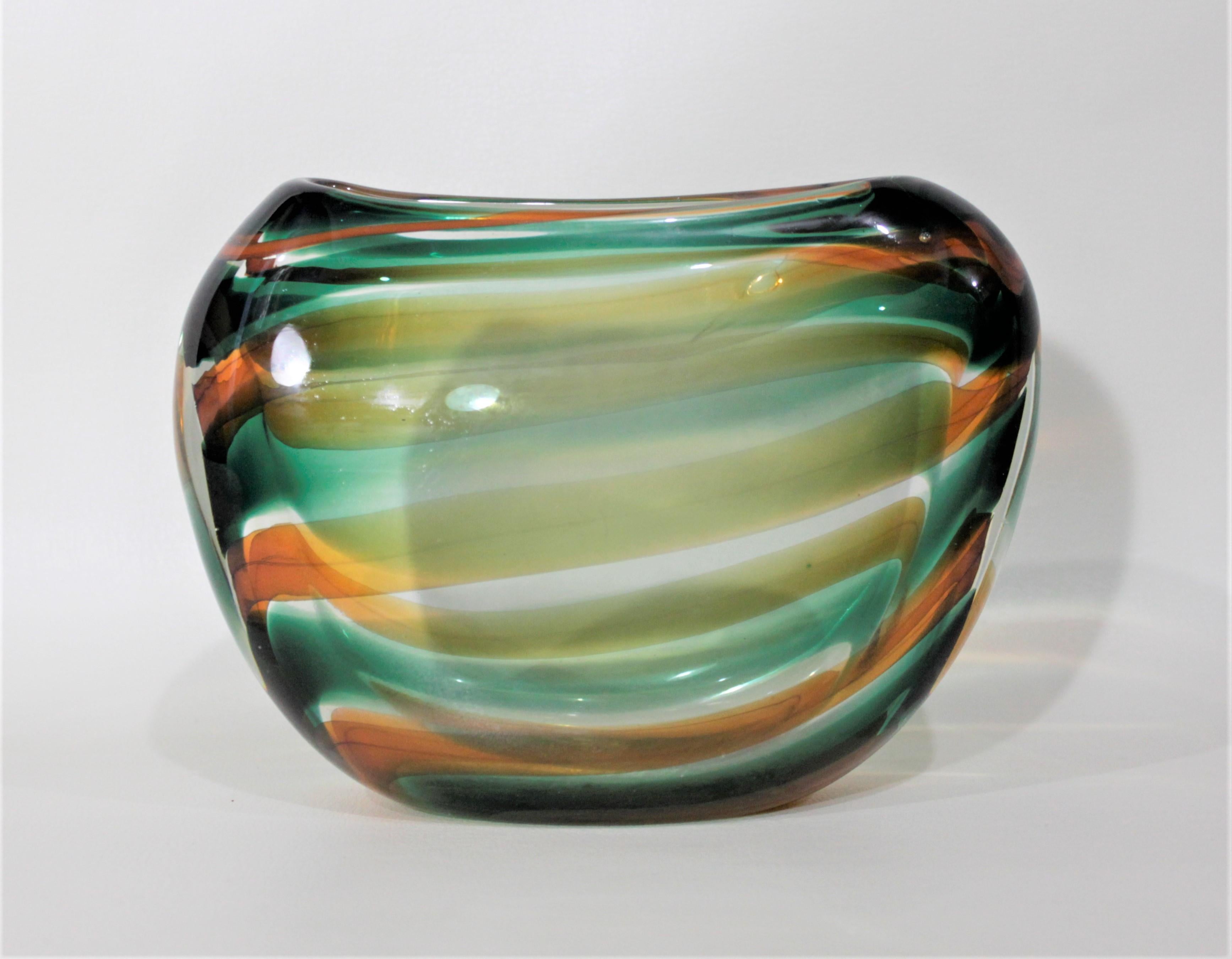 This Mid-Century Modern art glass vase was produced by the Leerdam Unica glass factory during the 1960s and although unsigned, can be attributed to the works of Floris Meydam The vase has very sleek lines and is done in vertical swirling stripes of