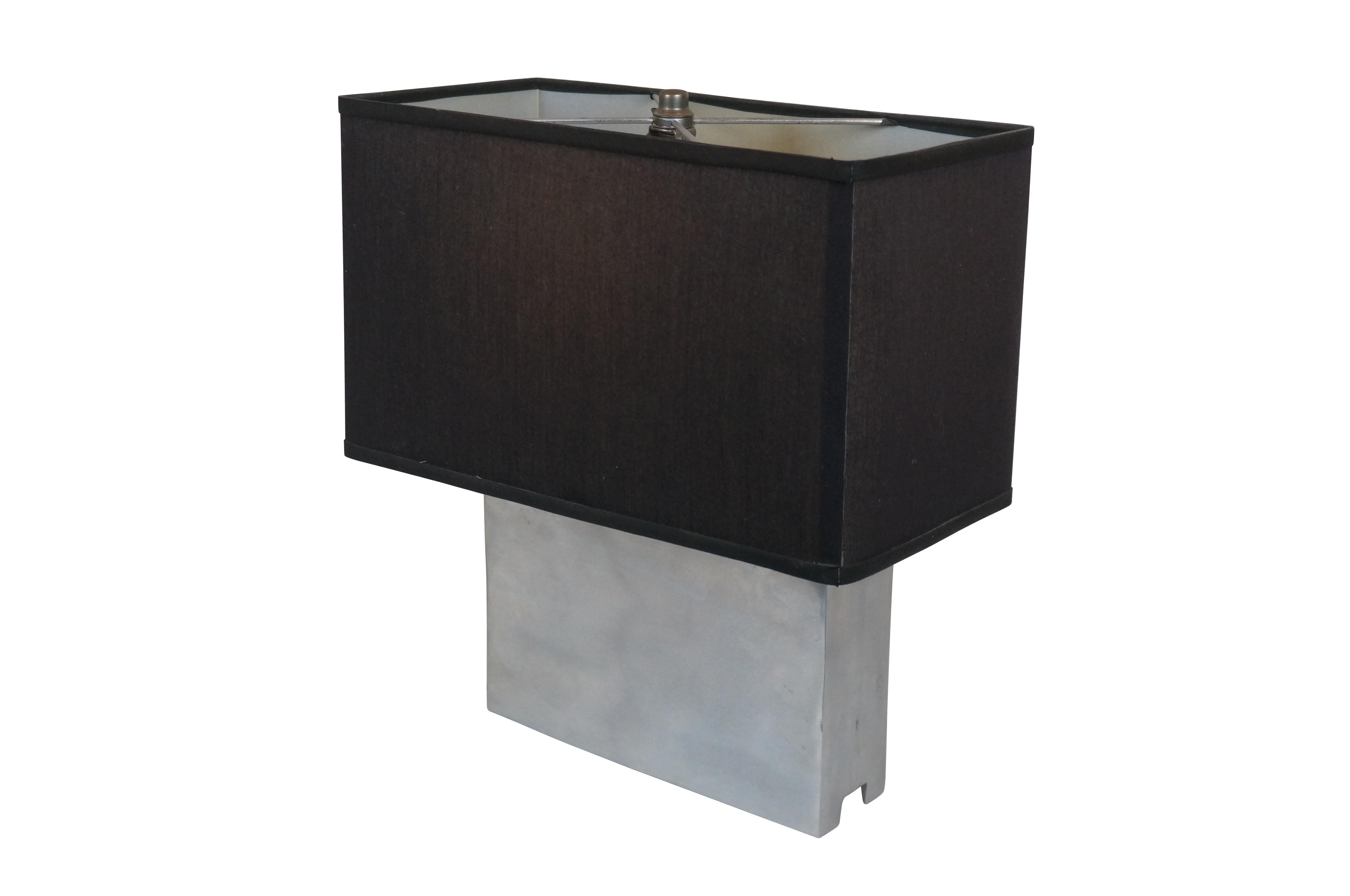 Mid century modern Leonard R. Foss cast aluminum rectangular table lamp with chrome finish. Includes harp, cap-shaped finial and black fabric shade.

Dimensions:
10