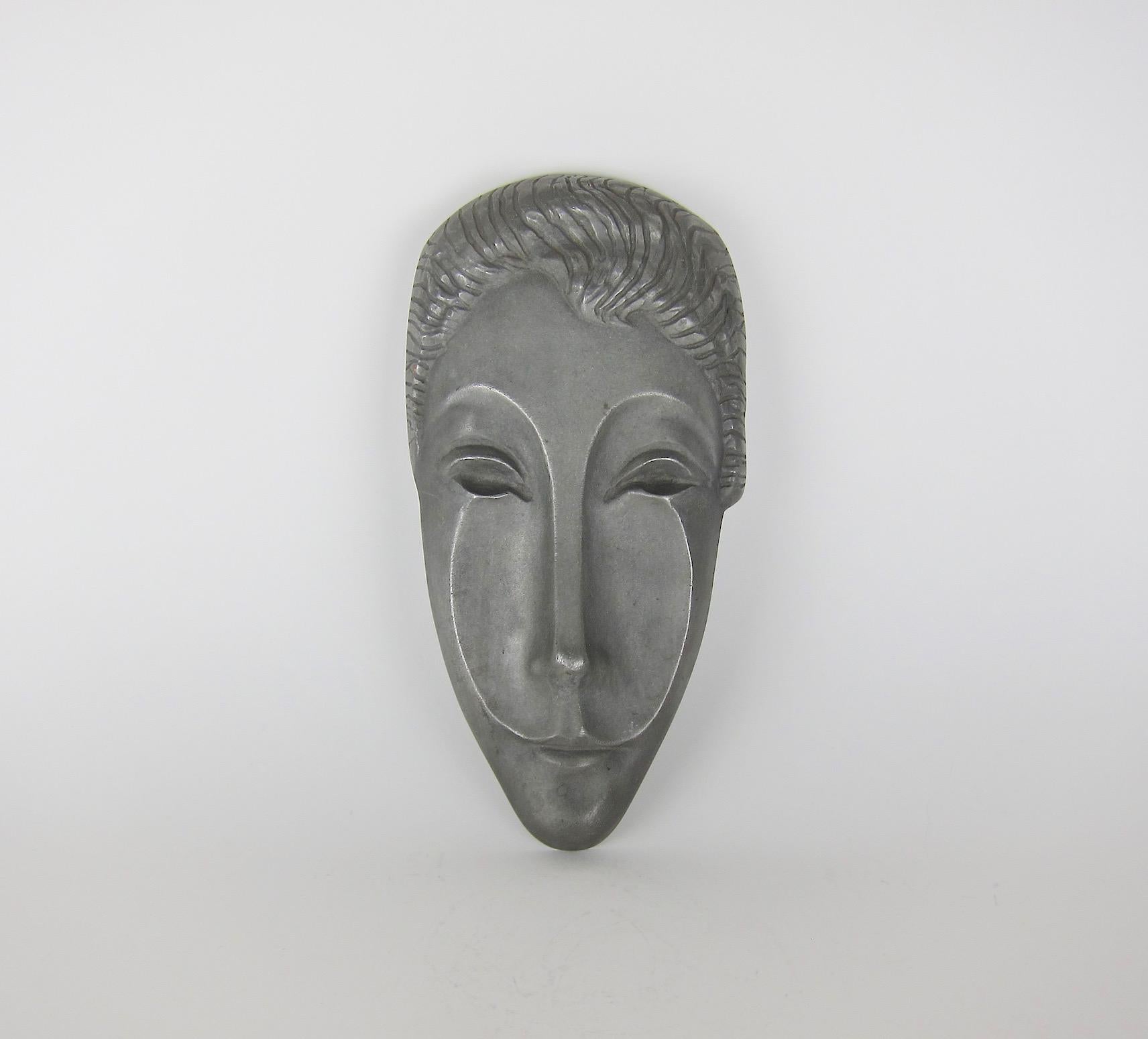 A midcentury wall sculpture of Letitia, the Roman Goddess of joy, gaiety, and happiness, by American sculptor Evaline Clark Sellors (1903-1995). The elongated and abstracted face of cast aluminum dates circa 1960 and is in very good condition with