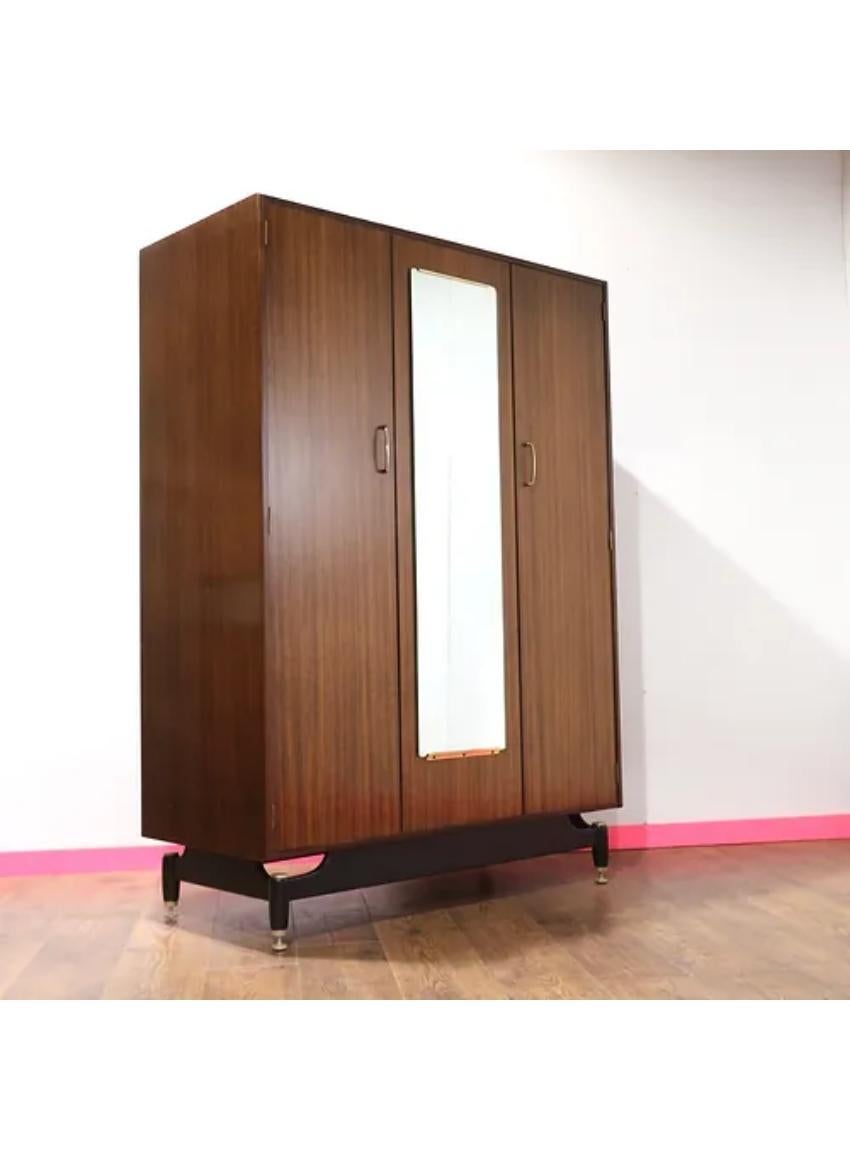 A stunning Mid Century armoire by G Plan as part of their Librenza range. This is a great looking classic with plenty of storage as well as a usefull mirror

All detailed with the G Plan handle design in brass and further brass detailing throughout.