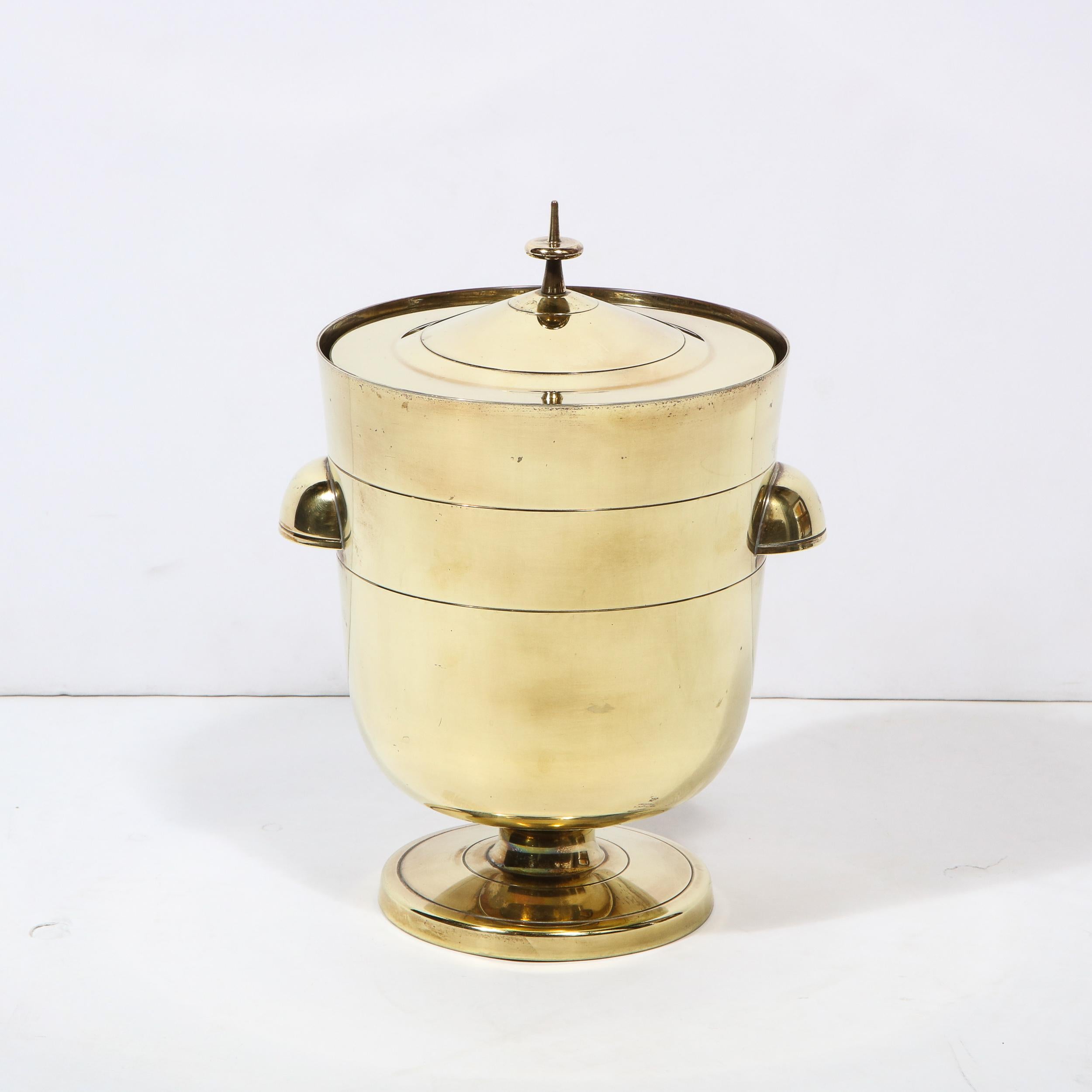This elegant Mid Century Modern ice bucket/ wine cooler was designed by the legendary Tommi Parzinger for Dorlyn Silversmiths circa 1960. It offers a striated circular slightly convex base with a cylindrical neck and a bullet form cylindrical body