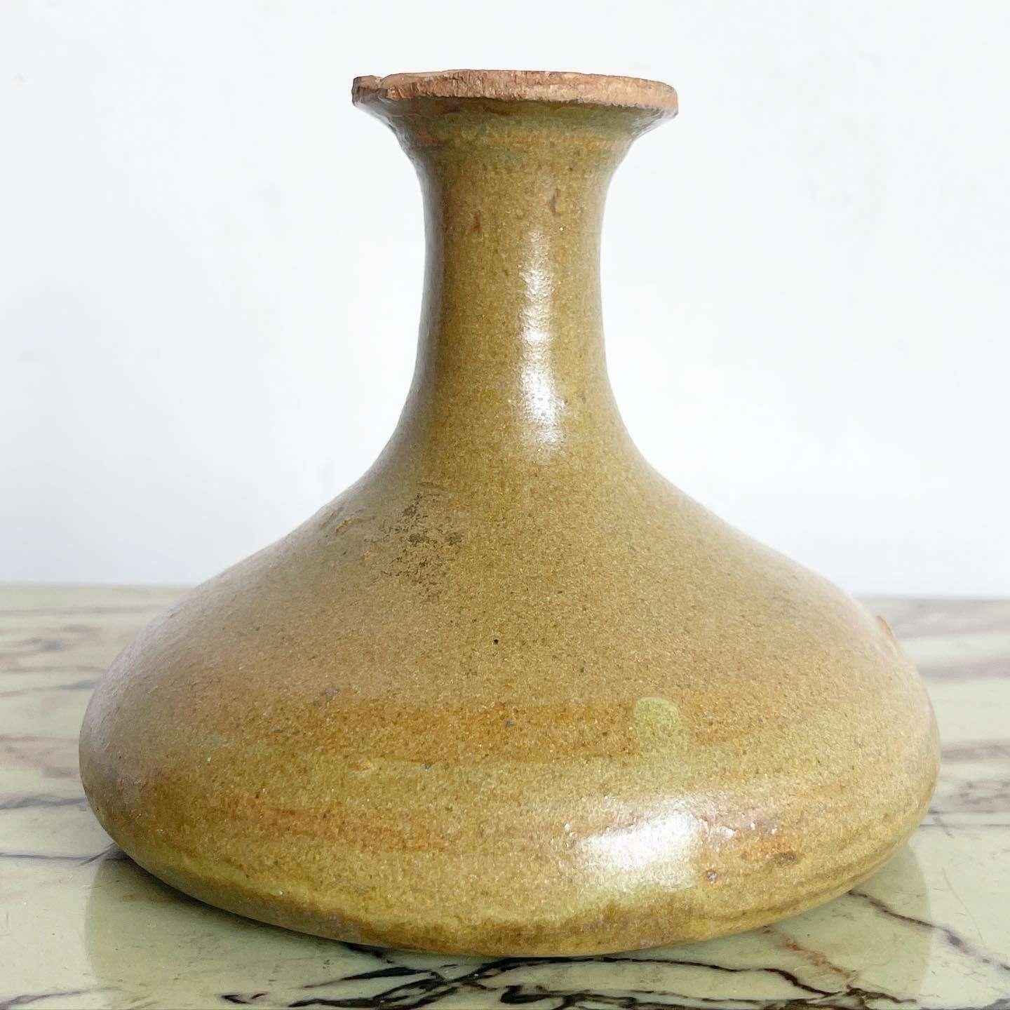 Embrace the timeless elegance of this exceptional vintage mid-century modern pottery vase. Handmade with care, this vase showcases a beautiful light brown hue and a graceful tulip shape, making it a stunning centerpiece for any mid-century or