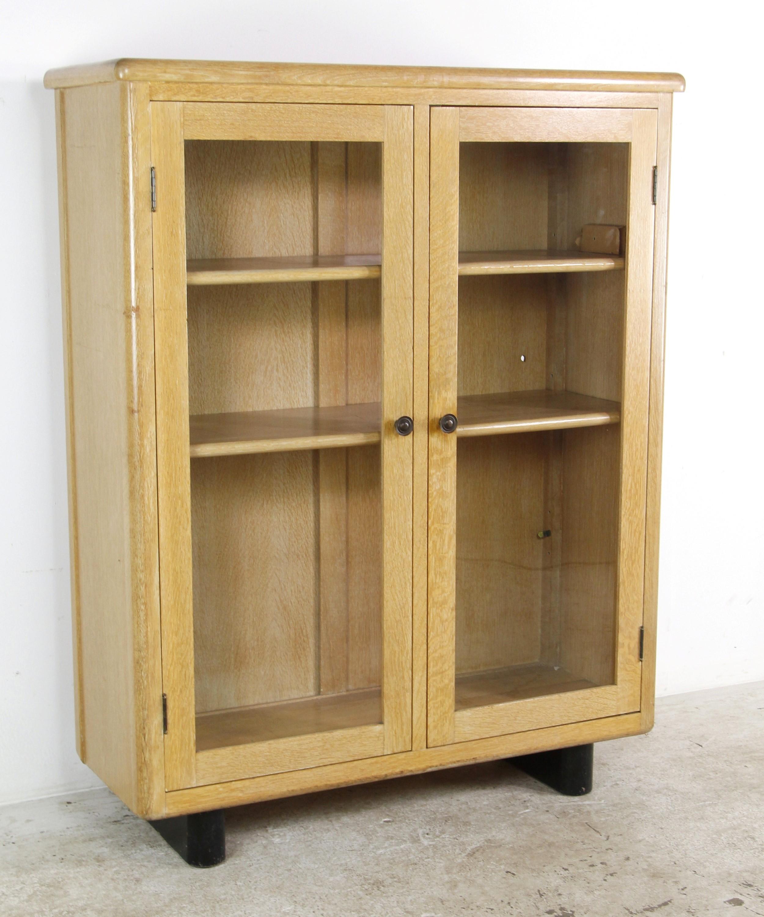 Mid-Century Modern solid oak bookcase cabinet featuring a clean-lined design with two glass cabinet doors. Its simplistic style and features make it a very practical piece of furniture. Please note, this item is located in one of our NYC locations.

