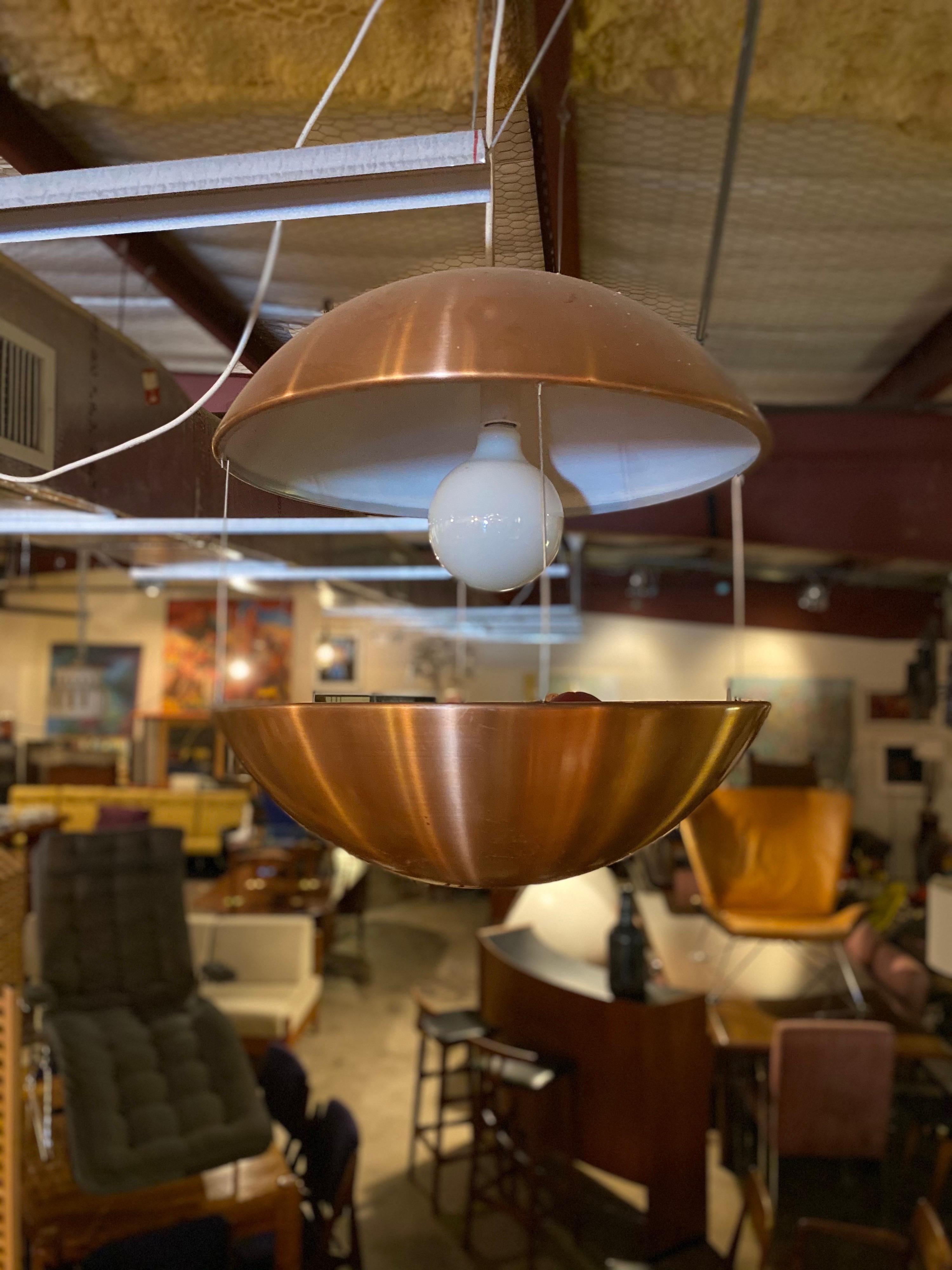 Mid-Century Modern lighted planter pendant is made of copper-plated aluminum with white enamel on the inside consists of two halves and is hung together by three steel rods. The electrical cord is approximately 10ft. This modern lighted planter is