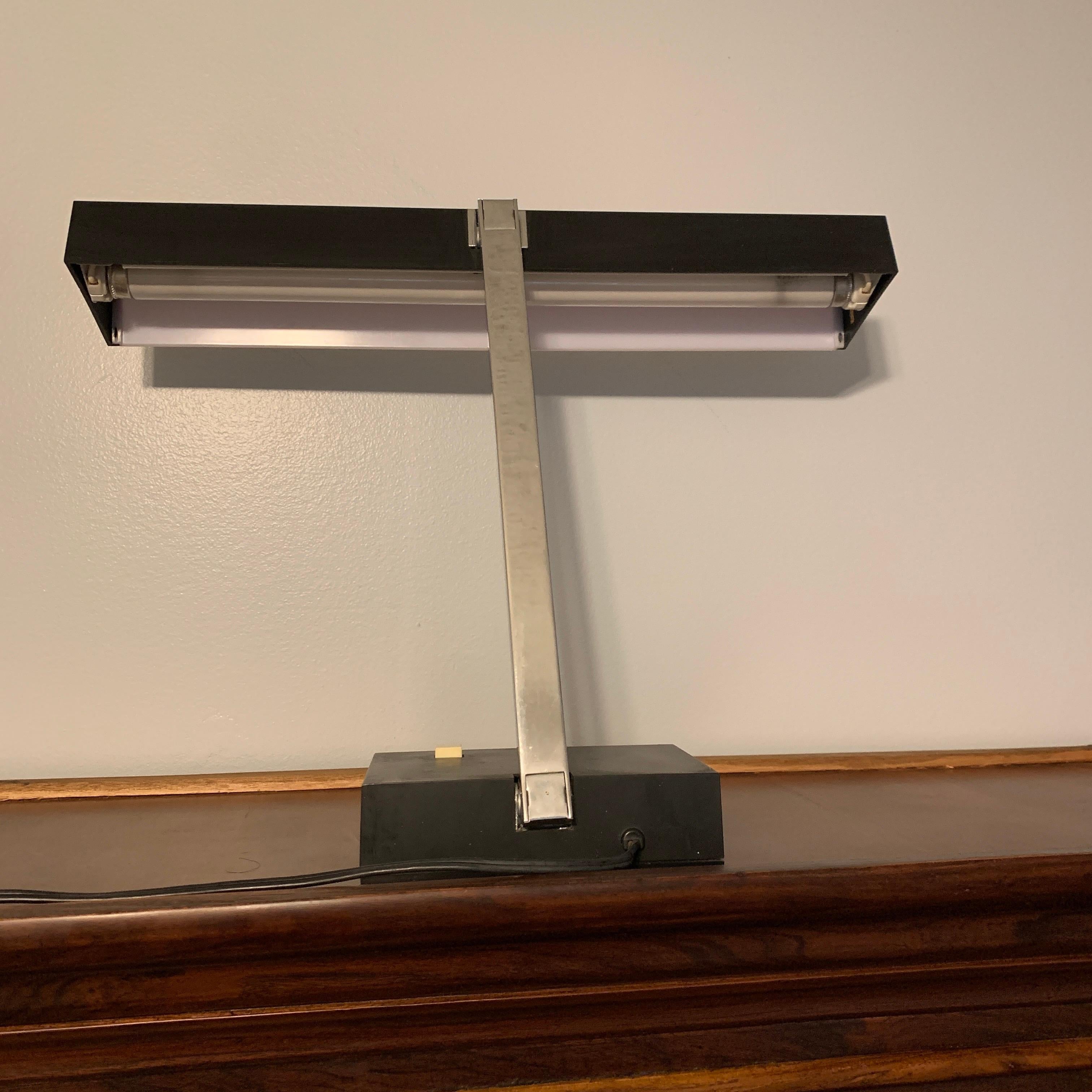 Super cool vintage Lightolier desk lamp. It’s perfect for the mid-century modern office! Sleek design and clean lines. Made from hard plastic composition mostly aside from the neck and parts of the base. Some light, superficial scratches, not