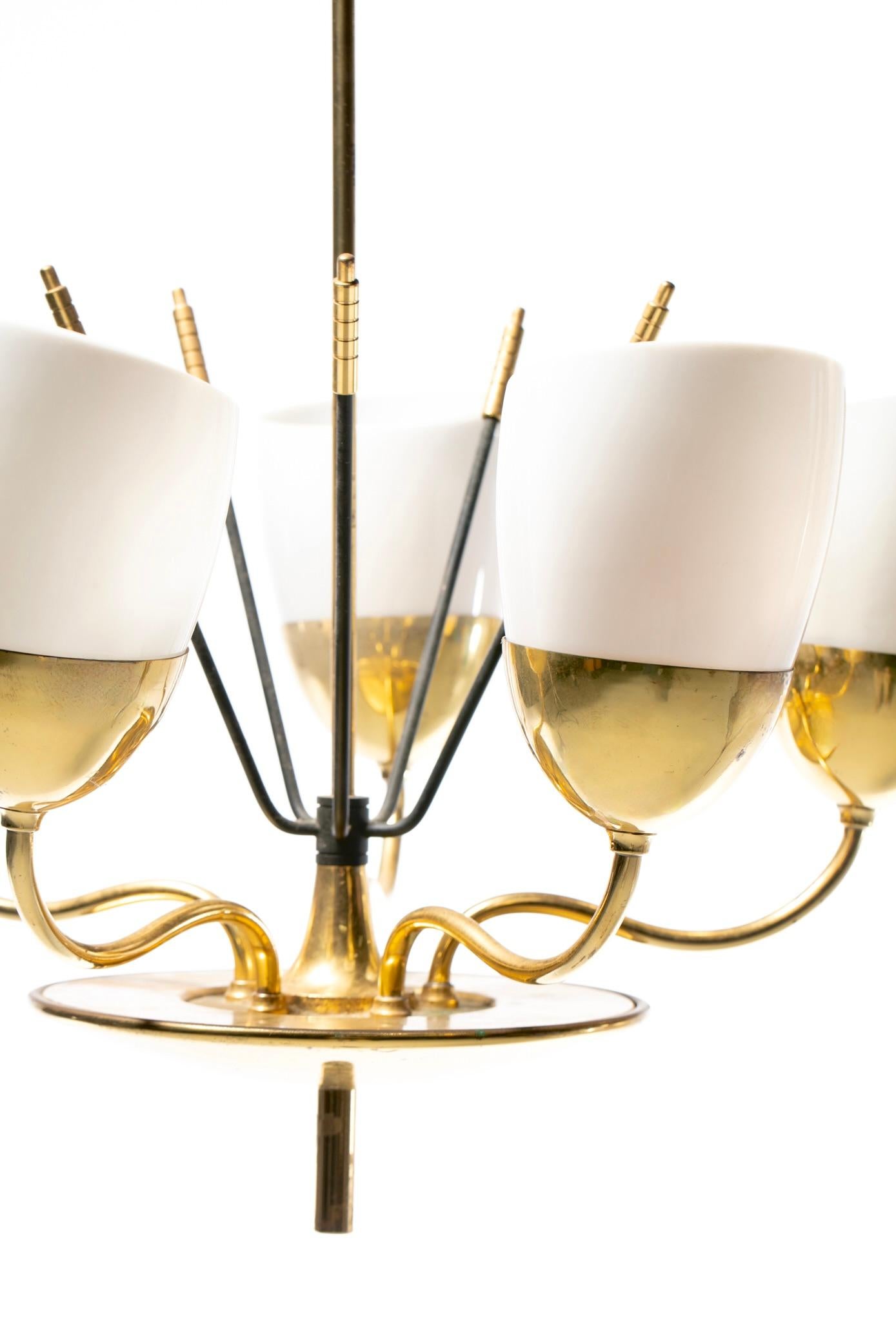 Lustre en laiton, métal peint et verre de style moderne du milieu du siècle, fabriqué par Lightolier vers les années 1950. Le contraste entre les bras en laiton doucement incurvés et les tiges centrales en métal noir confère à ce lustre une