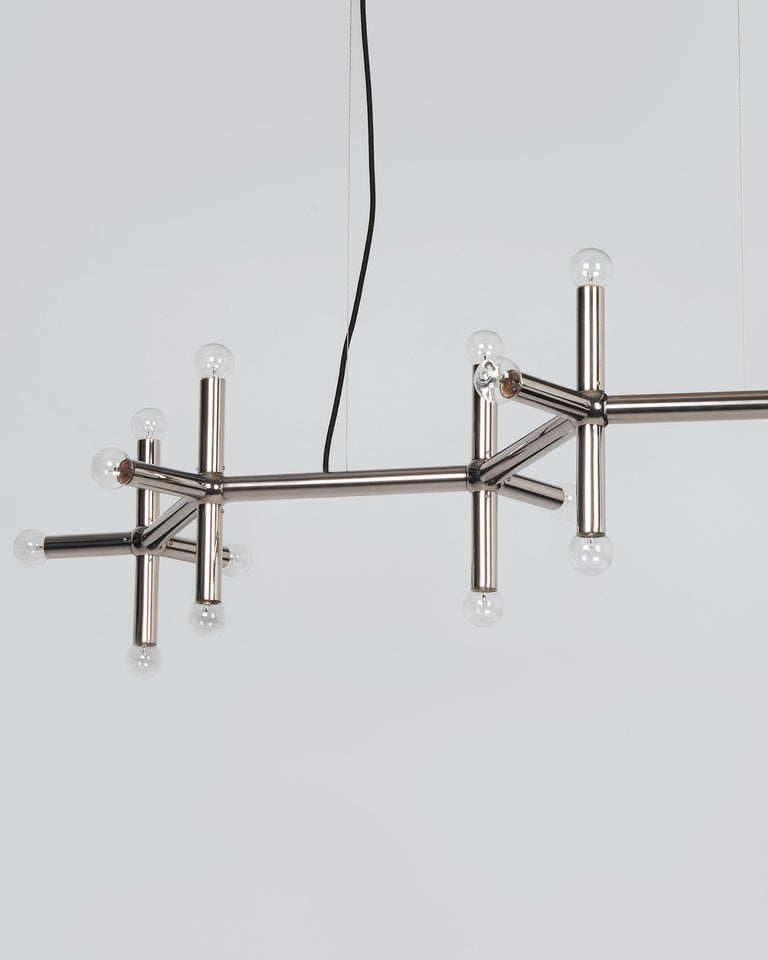 HHL6105

A linear arrangement of solid brass bars and spheres, this 20 light molecule chandelier is a zigzag of lines and connections. Each of the protruding segments ends in a point of light and the ensemble is suspended by minimalist braided