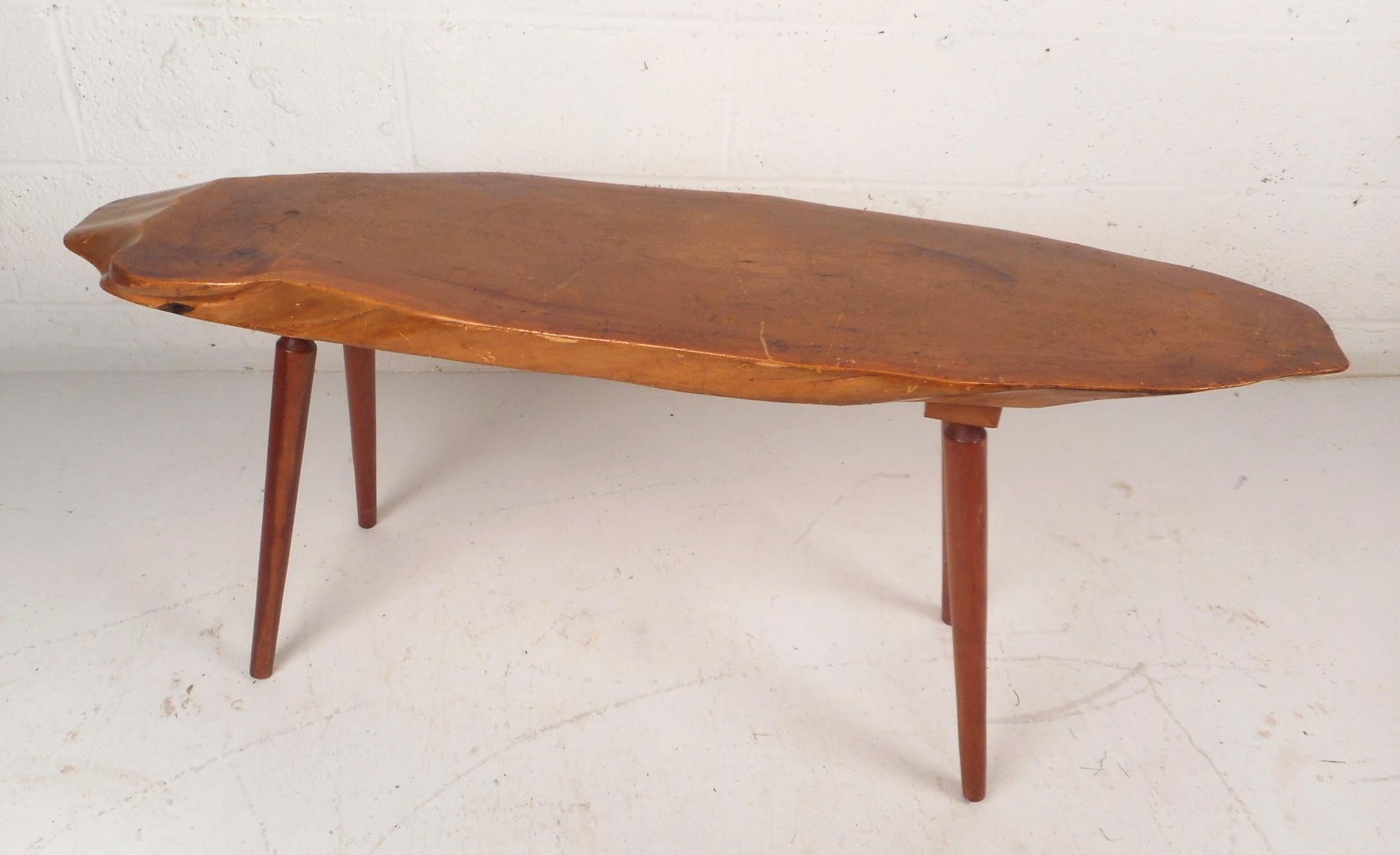 This gorgeous vintage modern coffee table features a live edge tree slab top with tapered legs. Unique design offers a sturdy and stylish place to set items in any modern interior. Please confirm item location (NY or NJ).