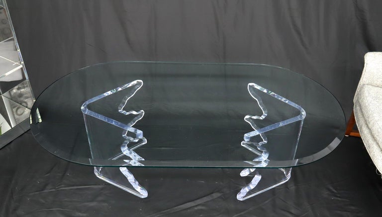 Mid-Century Modern oval glass top coffee table on thick Lucite base.