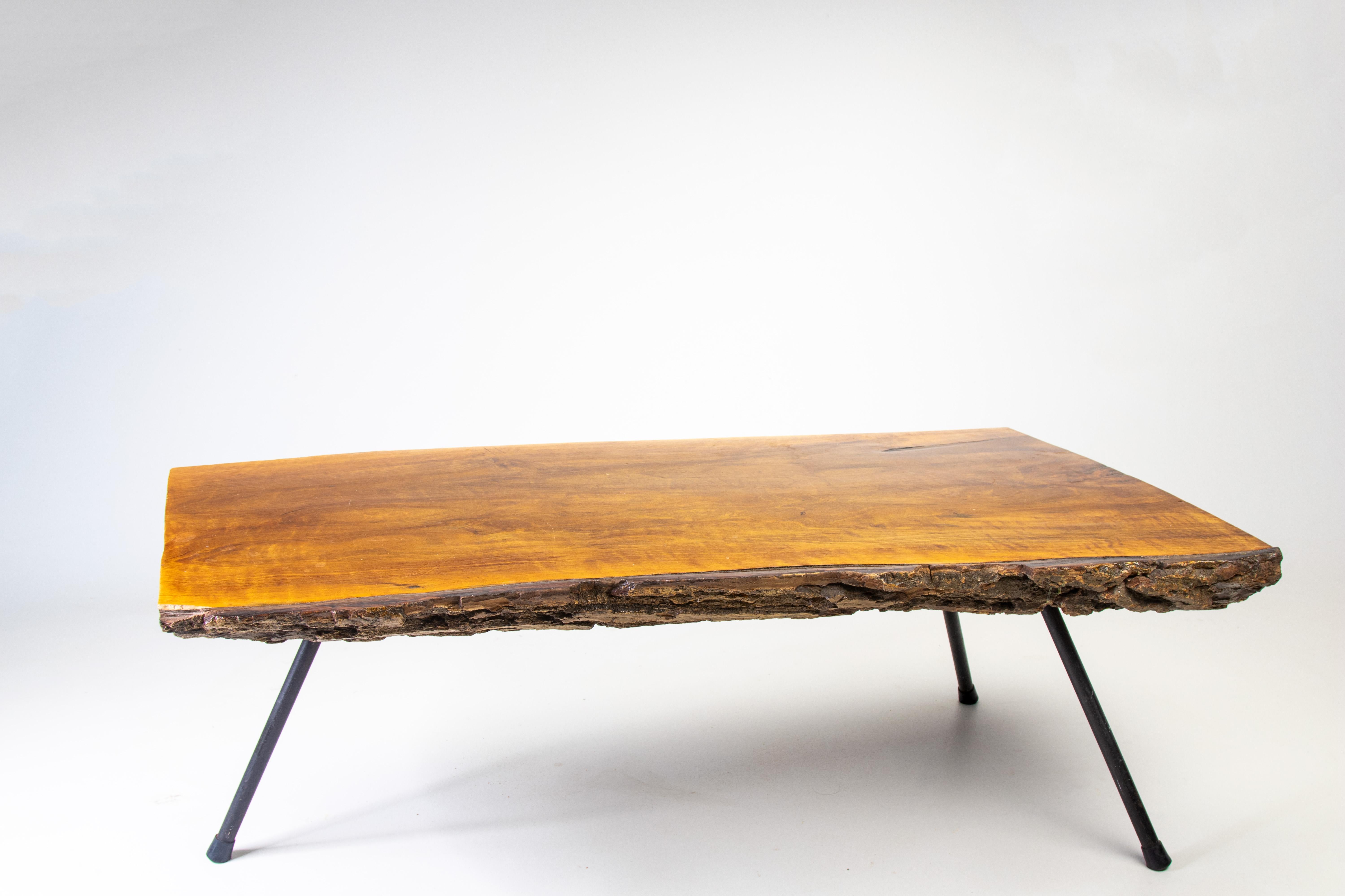 An organic modern coffee table in the manner of Carl Aubock.  A 1960s table featuring a pine slab with exposed bark, floating over a trio of iron legs with a great splay.  Heavy and vintage. San Diego California Provenance. 

Condition:

Unlevel
