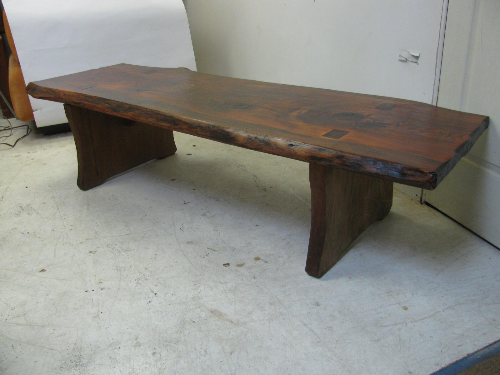 Elegant and simple live edge cocktail table. Large slab that is wide (24in. x 67in x 16.5in hgt.) and long. Slab style base is mortised thru the top and locked in with splines. Well constructed piece, very sturdy. Can also be used as a bench.