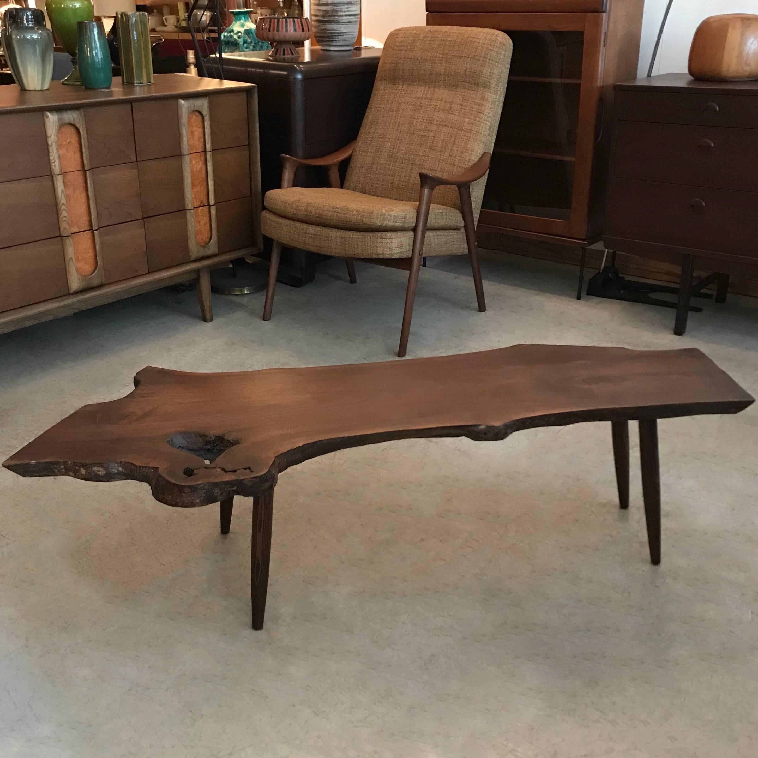 Custom, Mid-Century Modern, coffee table features a beautiful, vintage slab of knotted, live edge, walnut paired with tapered walnut legs.