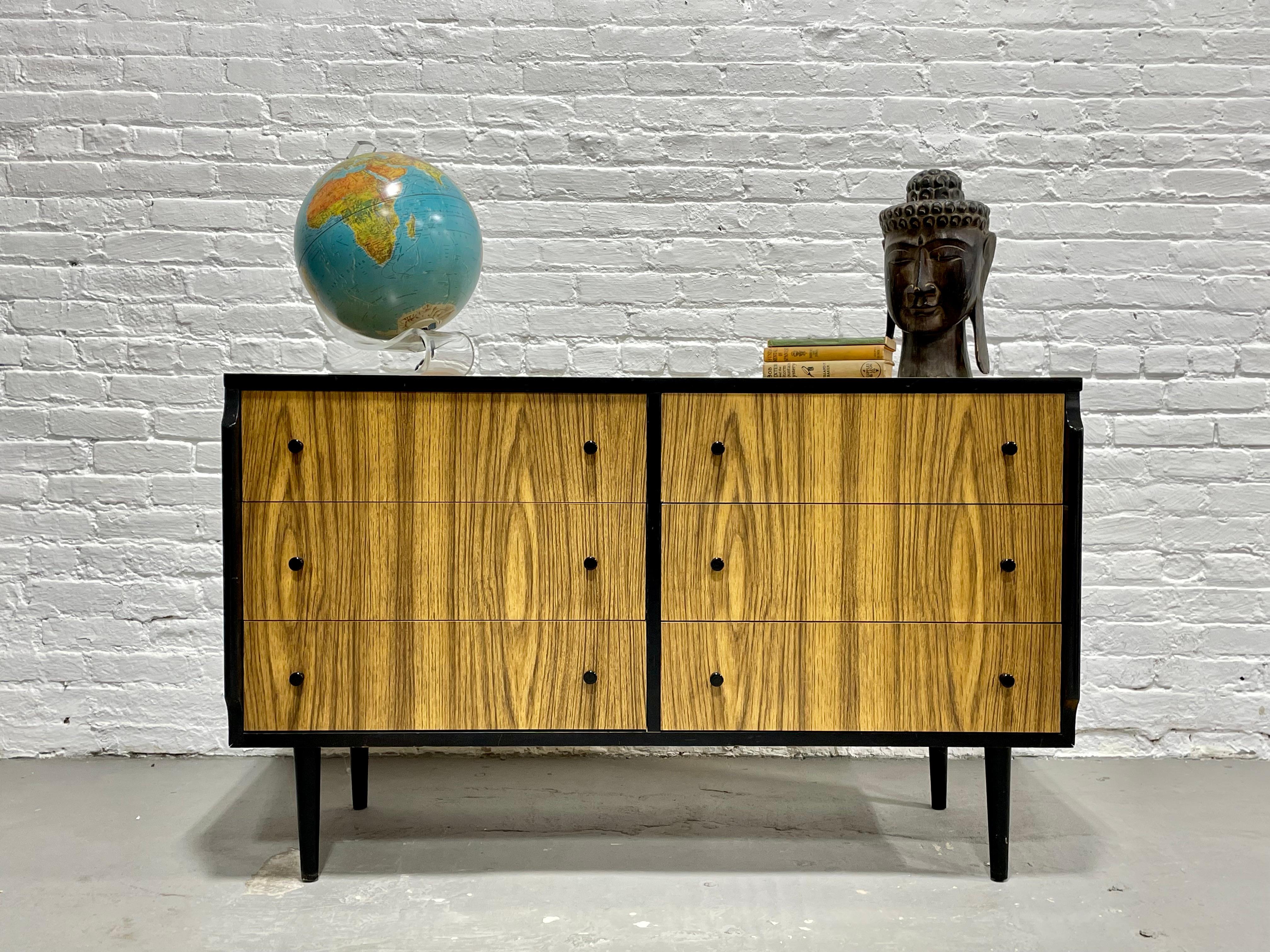 Mid-Century Modern Credenza / Long Dresser by Kent Coffey’s Teakway Line, a super fun ebonized and laminated design. The dresser is made of solid wood with woodgrain laminate over the top and drawer fronts. The dresser has six deep and spacious