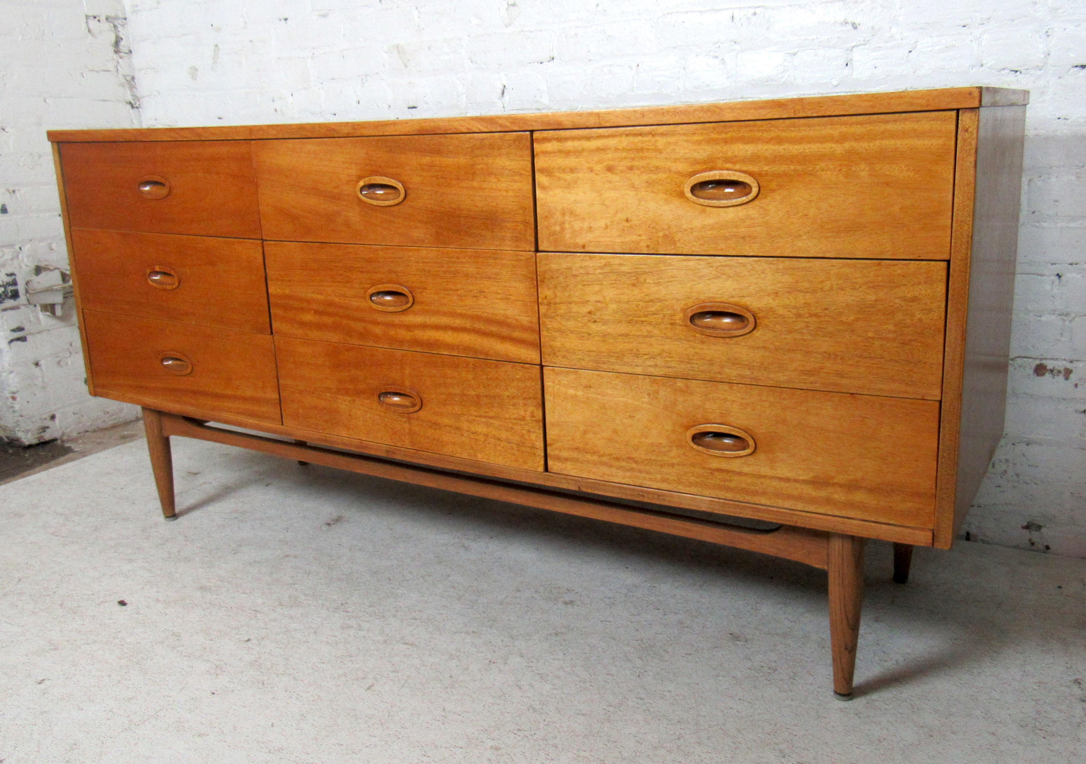 Sleek Mid-Century Modern nine drawer dresser featured in rich wood grain on sturdy tapered legs.

(Please confirm item location - NY or NJ - with dealer).