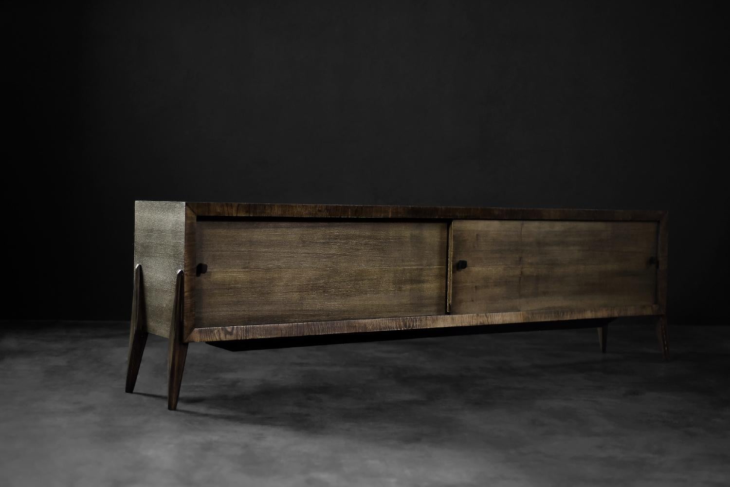 This modernist, long sideboard was made in Scandinavia during the 1960s. It is made of noble ash wood. The final layer was finished in an earthy brown color with visible strong grain and shade transitions. The front consists of a pair of sliding