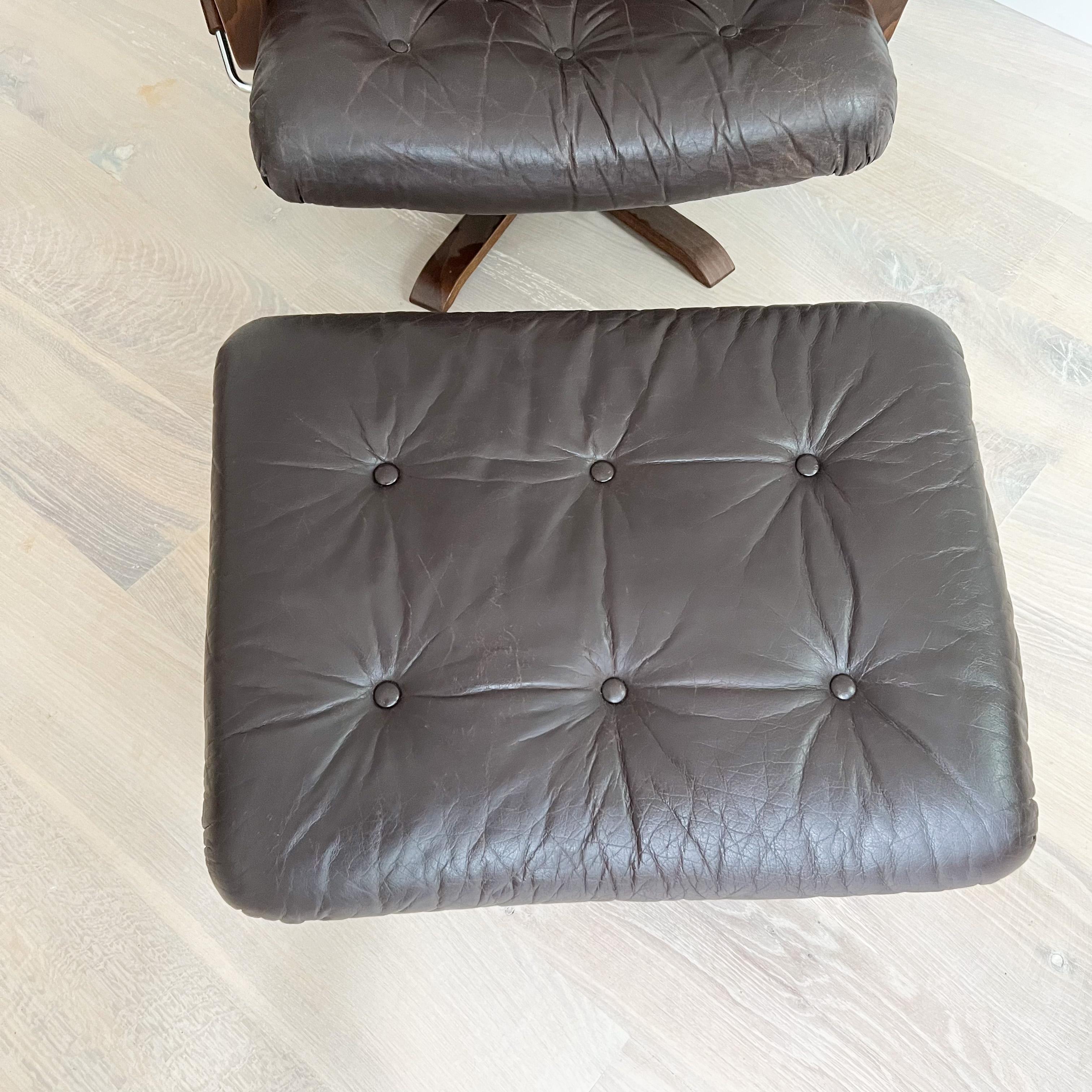Mid-Century Modern danish lounge chair and ottoman. The original brown leather is in good condition overall - Some light scuffing/scratching to the leather finish and wood frame from age appropriate wear.

The lever on the side doesn’t seem to