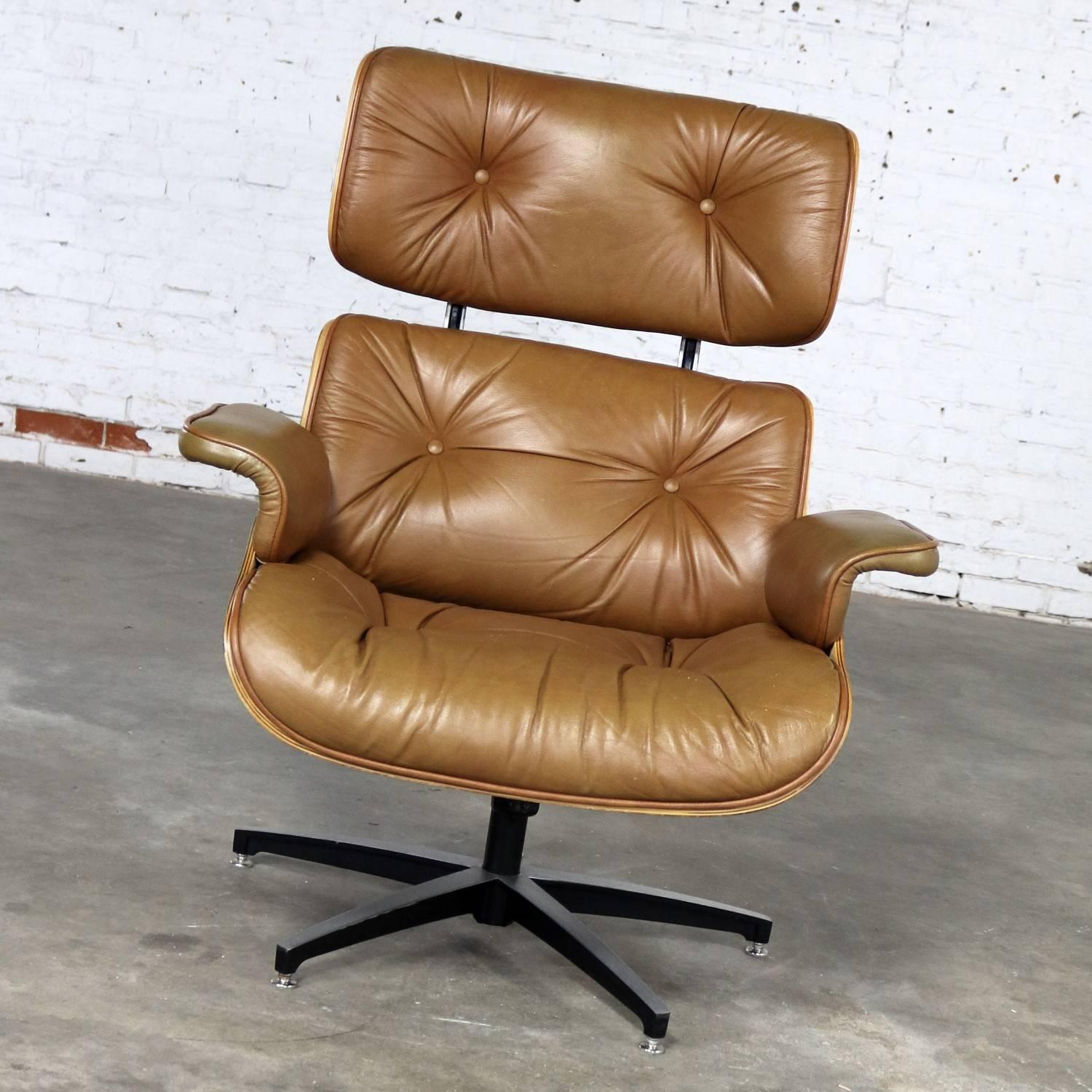 This Eames-style, Naugahyde or leather-upholstered molded walnut lounge chair hails from the 1960s and is a classic reproduction of the iconic Eames lounge chair. Attributed to Selig Plycraft, this mid-century chair has gained a cult following, in