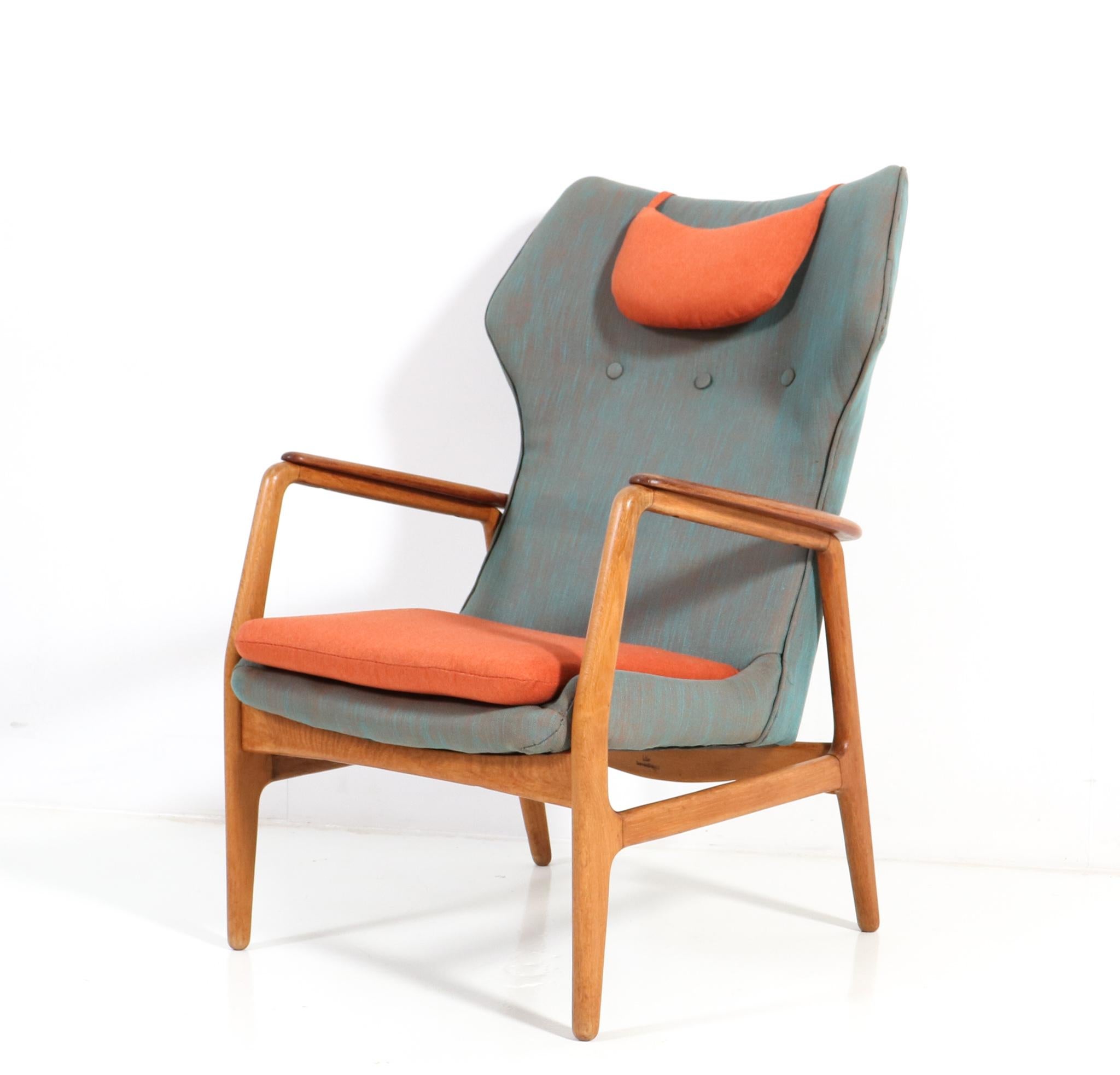 Stunning Mid-Century Modern lounge chair.
Design by Aksel Bender Madsen for Bovenkamp.
Striking Danish design from the 1960s.
Solid oak frame with solid teak curved armrests which goes around 
the backside also.
Re-upholstered with quality