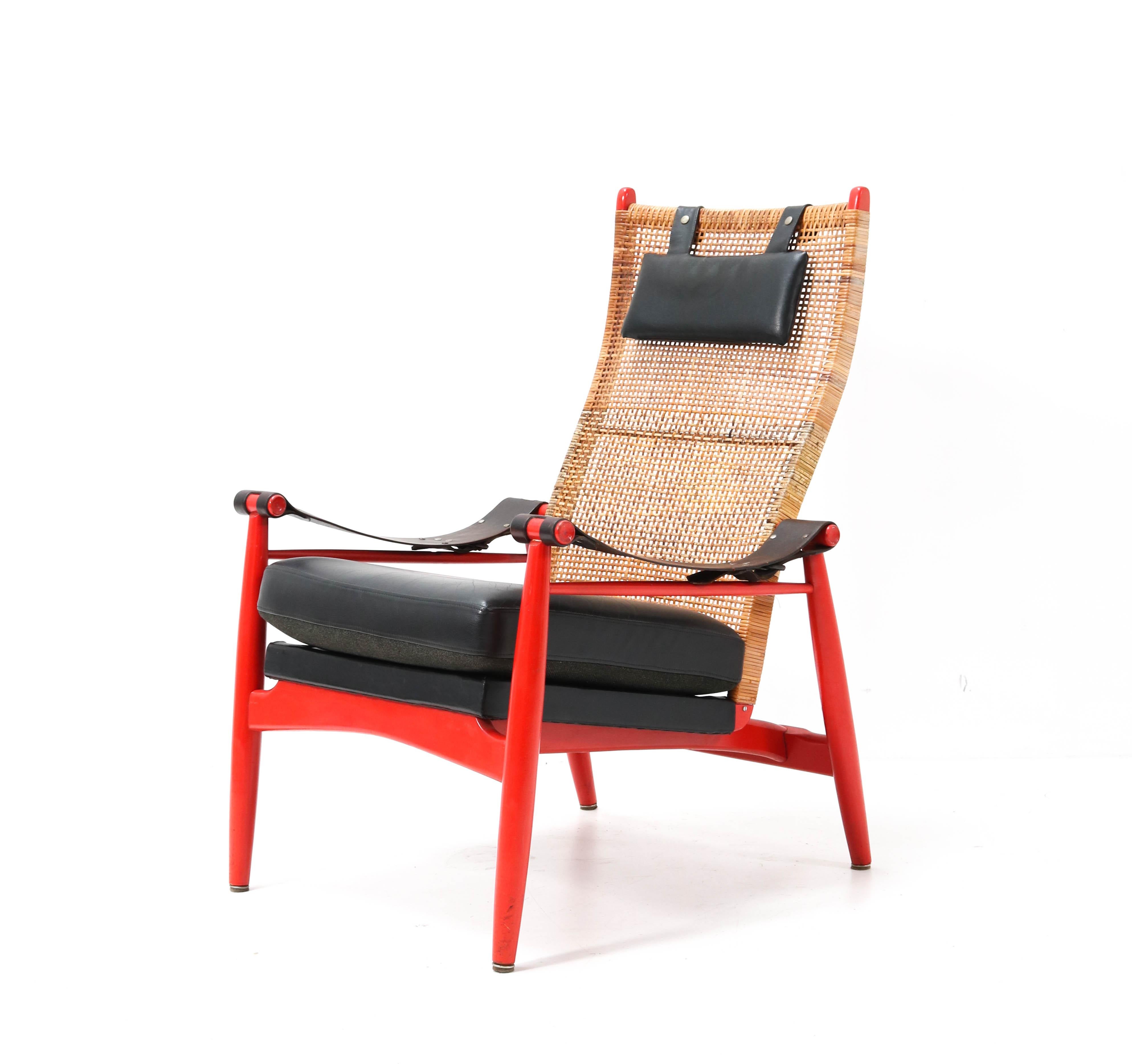 Stunning and rare Mid-Century Modern lounge chair.
Design by P.J. Muntendam for Gebroeders Jonker.
Striking Dutch design from the 1950s.
Red lacquered wooden frame with original leather armrests.
Original black leather cushion and black leather