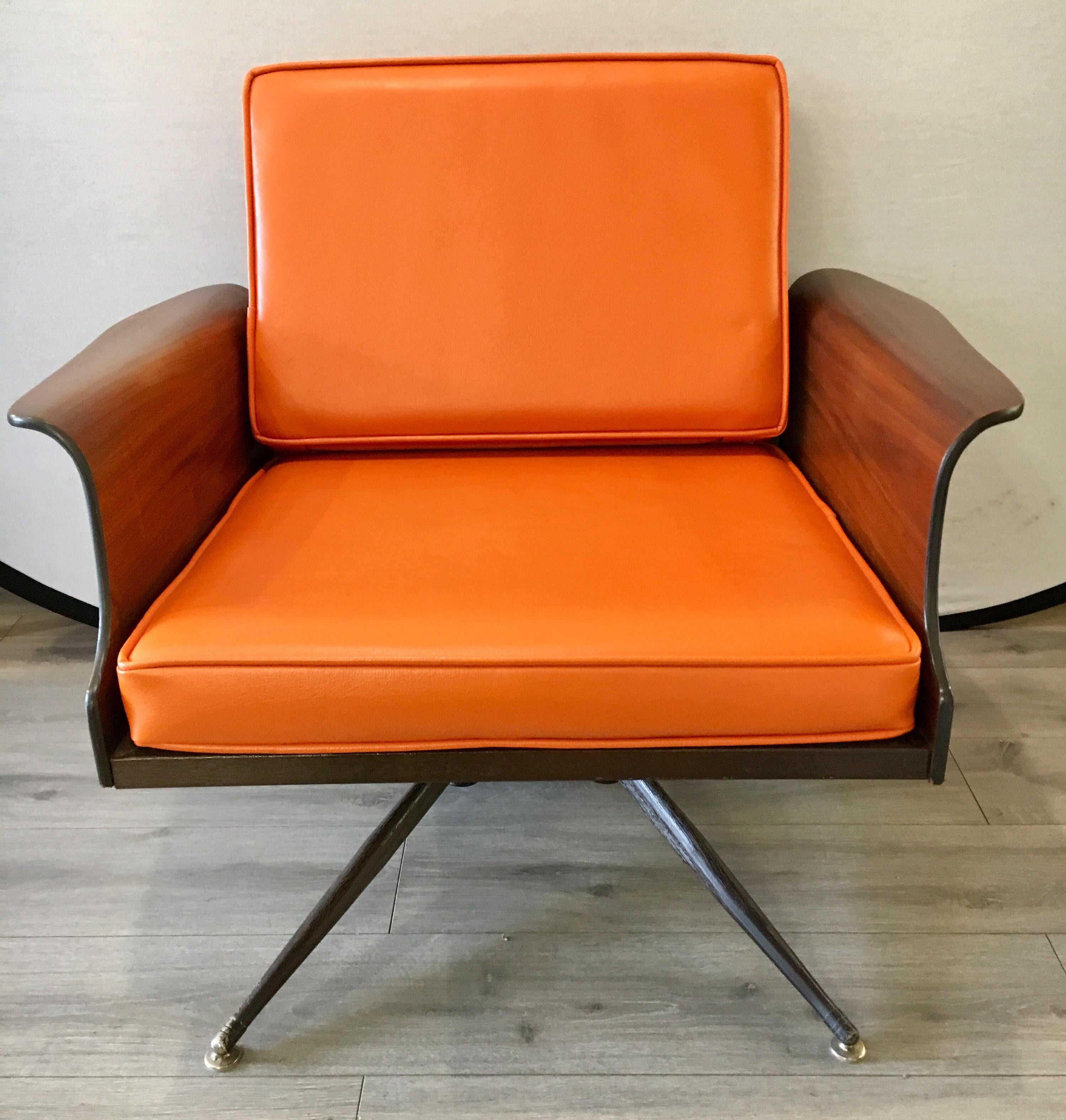 Coveted 1960s original lounge chair redone in a orange pebbled leather that looks gorgeous.
Features many Danish accents including the winged arm and streamlined legs. This chair does not swivel.