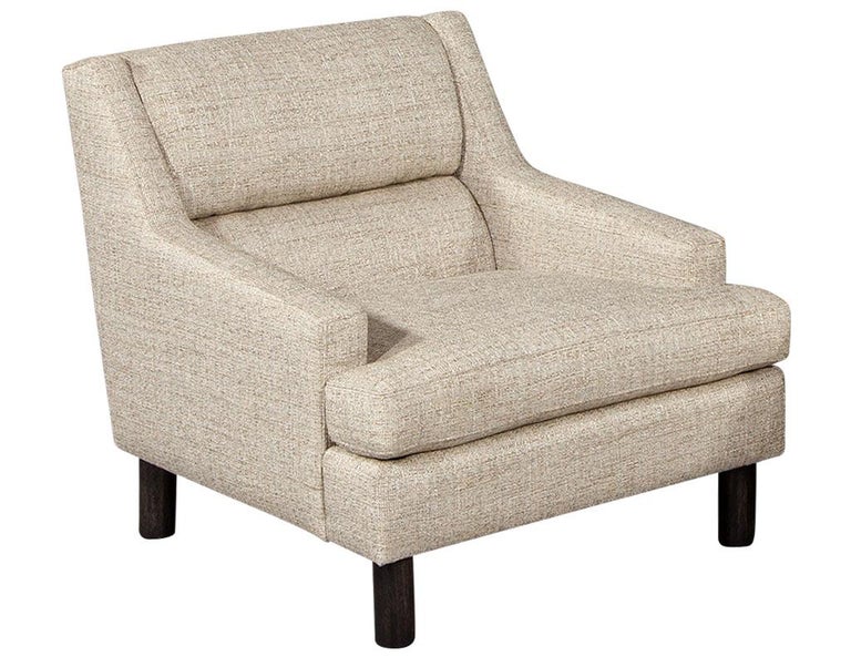 Mid-Century Modern Lounge Chair in Designer linen. Timeless mid-century modern design with comfortable large upholstered features. Upholstered in a textured sandy beige designer Linen with cylindrical walnut feet. Price includes complimentary curb