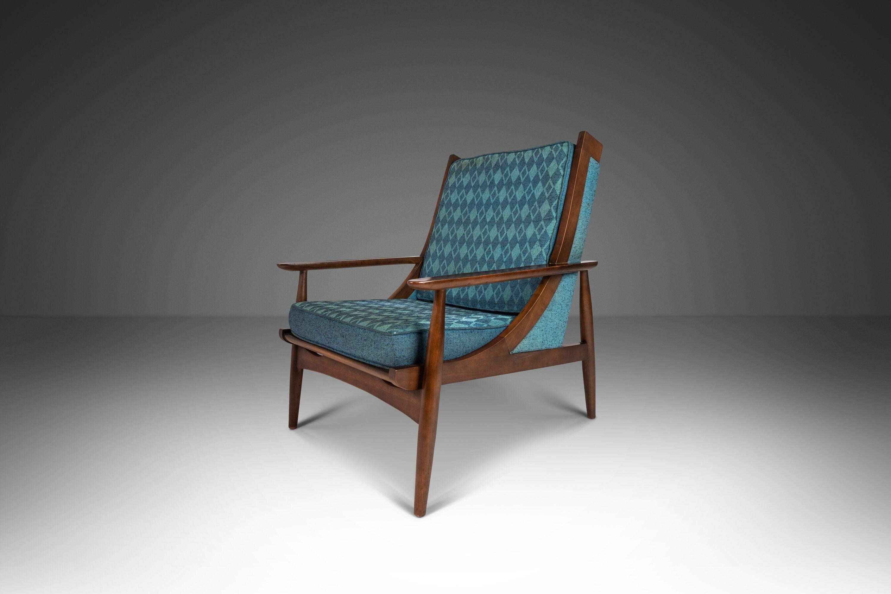 As stylish as it is comfortable this splendidly retro lounge chair is unlike any we've ever come across. Constructed of solid walnut and featuring graceful curves, inset-sculpted arms and intricate vertical backrest dowels this lounger truly