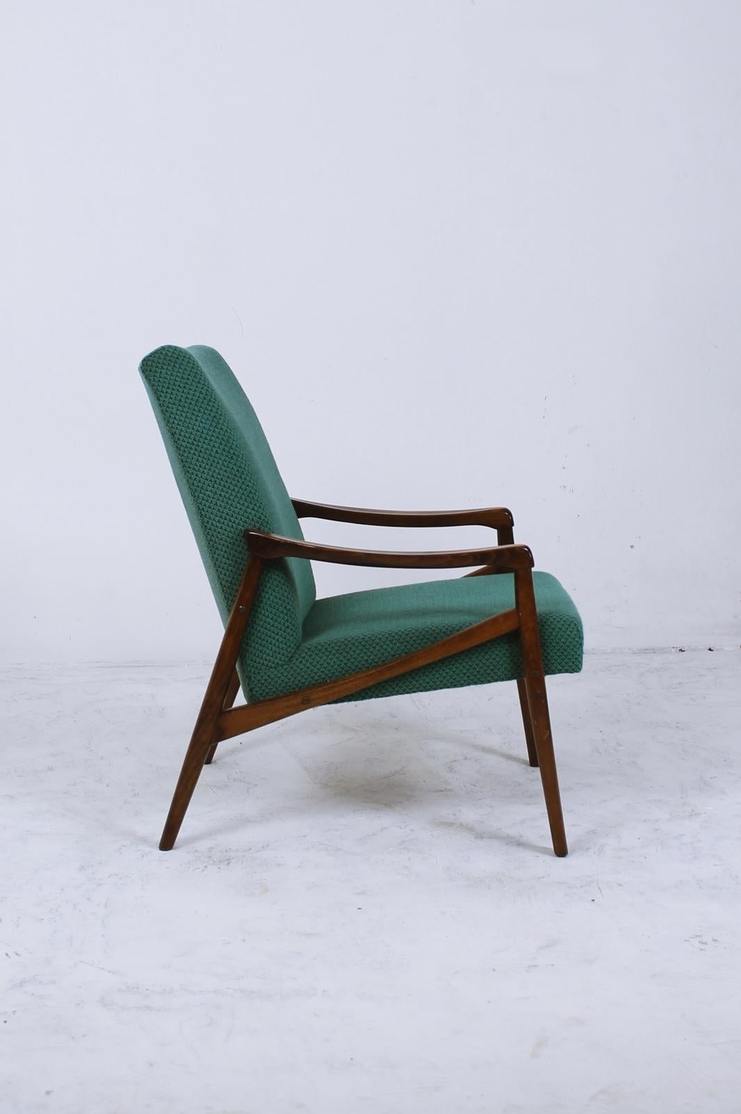 Stylish and elegant midcentury armchair by Interier Praha, produced in 1960s. Original upholstery in good condition with only minor wear. Beautiful stained beech wood frame with interesting details and strong construction.