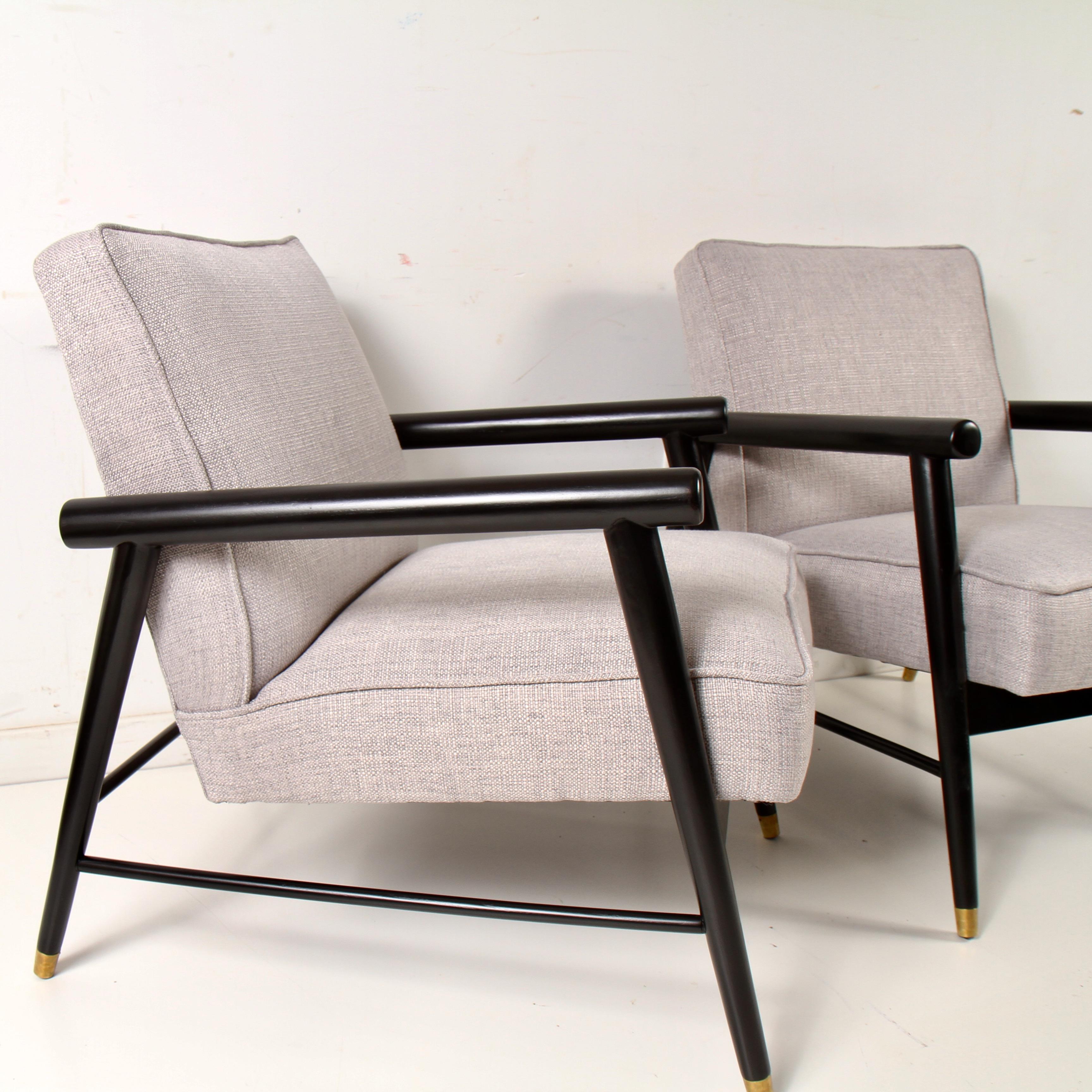 1950s era lounge chairs that have nee refinished and rebuilt from the ground up. Chairs have nee recovered in a light gray linen and the walnut frame has been refinished to its original ebony. They are well made, yet relatively easy to move. Great