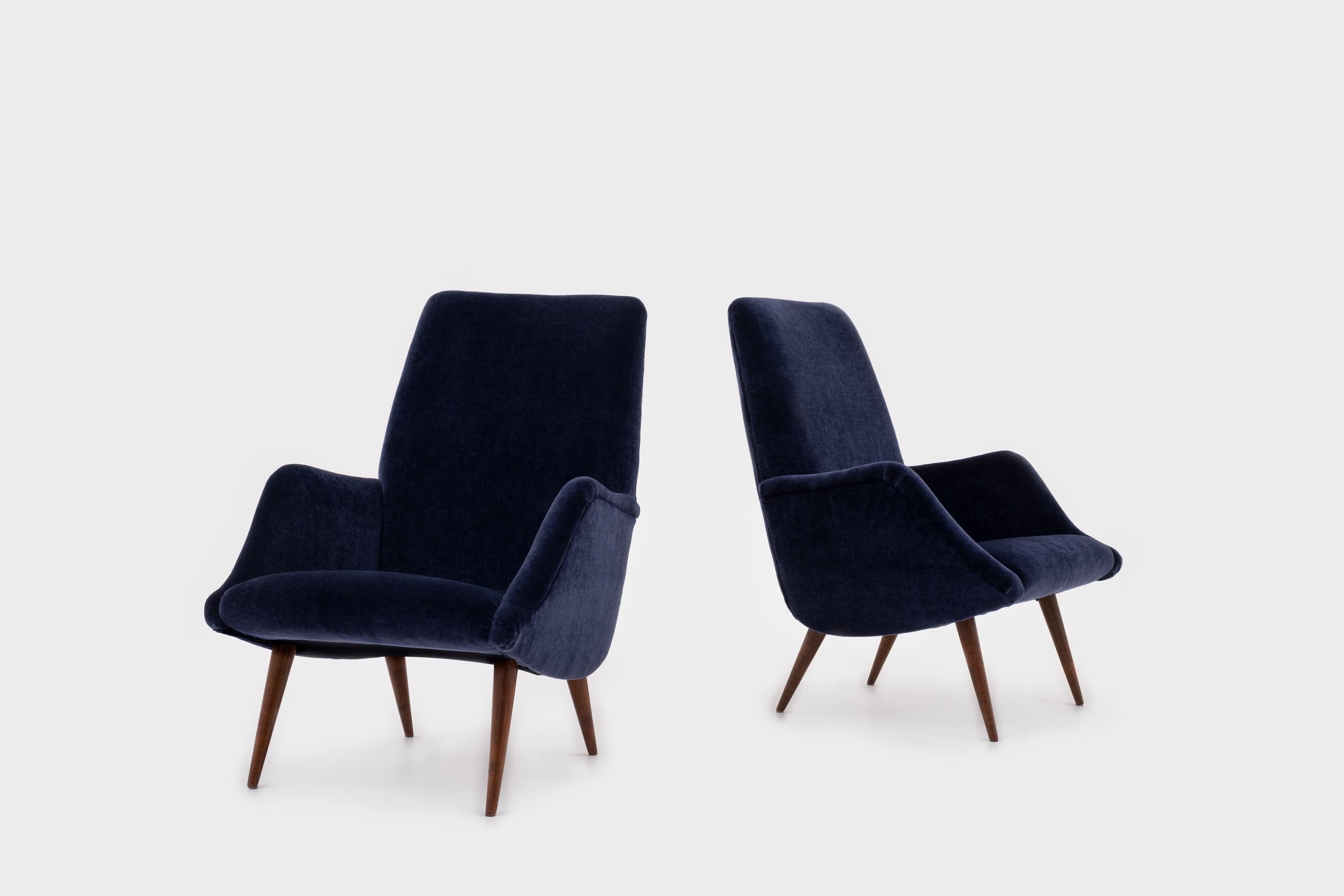 Beautiful pair of ‘806’ armchairs by Carlo de Carli for Cassina, Italy, 1955. Elegant curved shape with nice distinctive sharp tapered Italian walnut wooden legs. The chairs are fully reconditioned and are upholstered in a high quality night blue