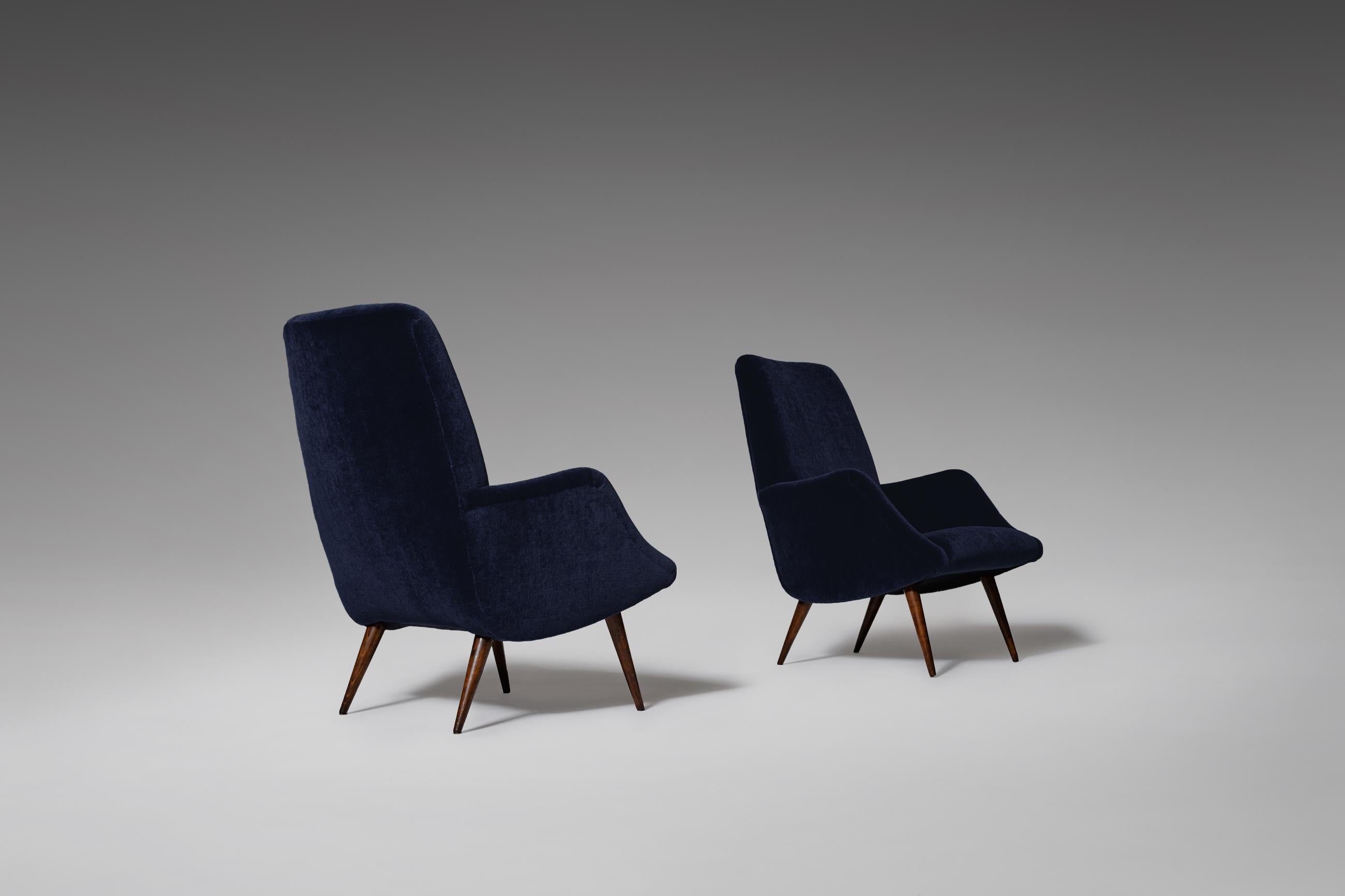 Beautiful pair of ‘806’ armchairs by Carlo de Carli for Cassina, Italy, 1955. Elegant curved shape with nice distinctive sharp tapered Italian walnut wooden legs. The chairs are fully reconditioned and are upholstered in a high quality night blue